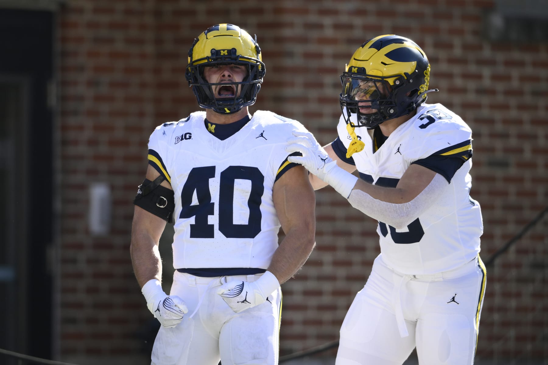 Michigan linebacker Christian Boivin (40) recast with linebacker Jimmy Rolder (30) after he blocked a punt during the first half of an NCAA college football game against Maryland, Saturday, Nov. 18, 2023, in College Park, Md. Michigan scored a safety on the play. (AP Photo/Nick Wass)