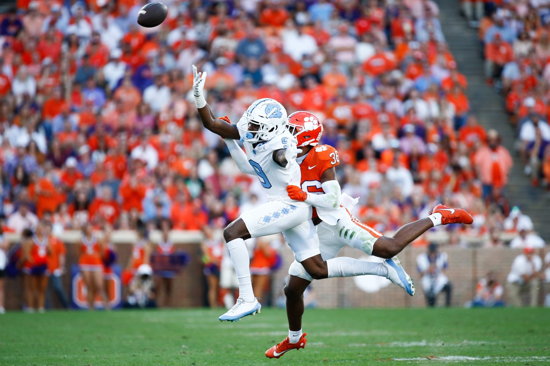 CLEMSON, SOUTH CAROLINA - NOVEMBER 18: Khalil Barnes #36 of the Clemson Tigers and Devontez Walker #9 of the North Carolina Tar Heels reach for the ball at Memorial Stadium on November 18, 2023 in Clemson, South Carolina. (Photo by Isaiah Vazquez/Getty Images)