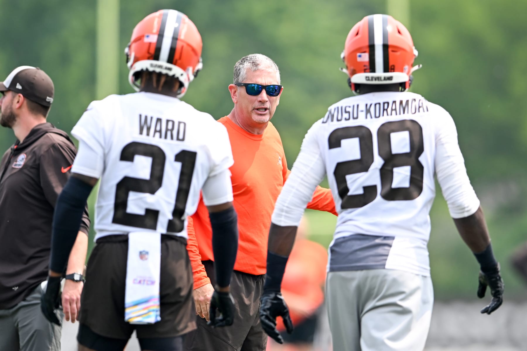 Cleveland Browns cornerback Denzel Ward (21), defensive coordinator Jim Schwartz (center) and linebacker Jeremiah Owusu-Koramoah (28)