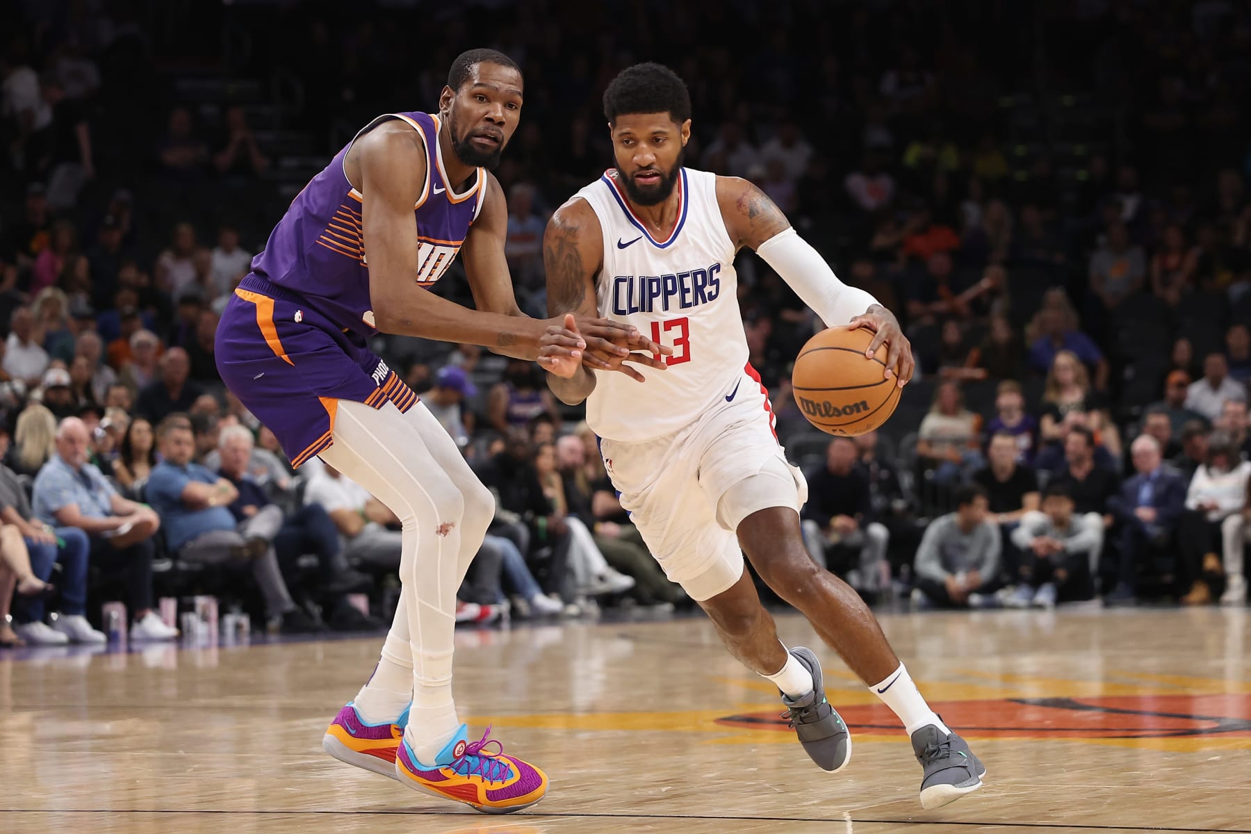 PHOENIX, ARIZONA - APRIL 09: Paul George #13 of the LA Clippers drives the ball against Kevin Durant #35 of the Phoenix Suns during the second half of the NBA game at Footprint Center on April 09, 2024 in Phoenix, Arizona.  NOTE TO USER: User expressly acknowledges and agrees that, by downloading and or using this photograph, User is consenting to the terms and conditions of the Getty Images License Agreement.  (Photo by Christian Petersen/Getty Images)