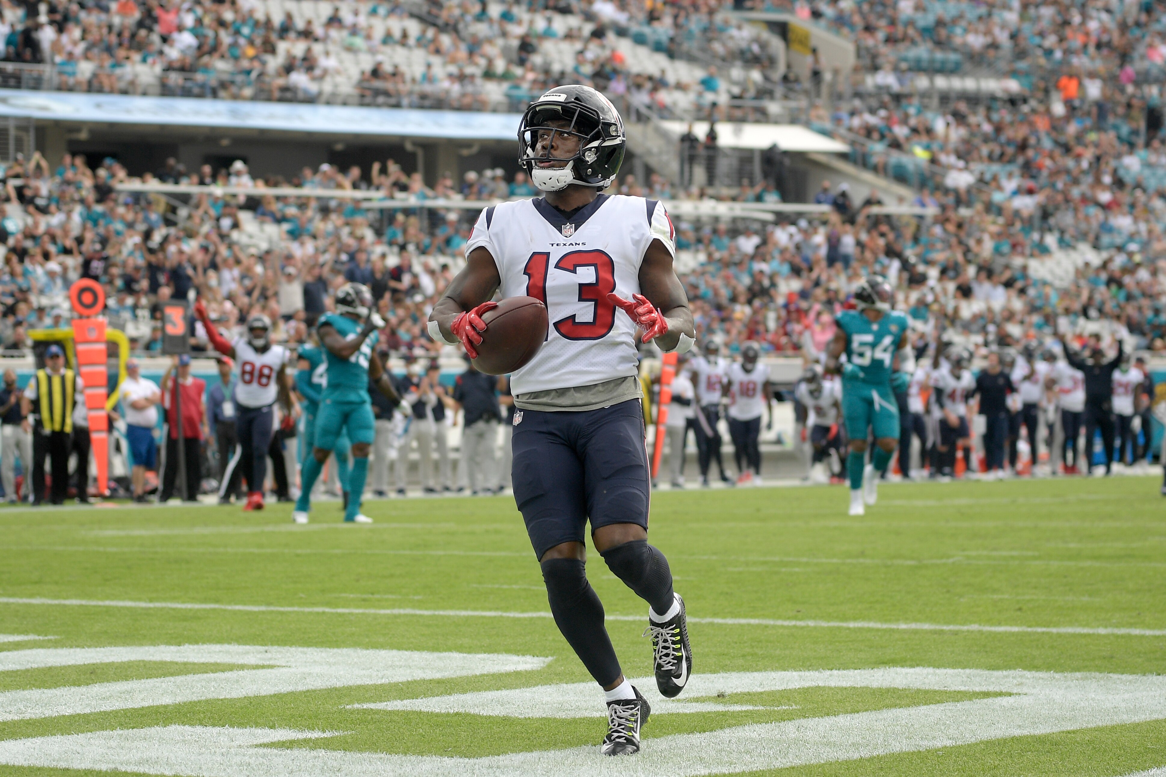 Houston Texans wide receiver Brandin Cooks (13) runs past Jacksonville Jaguars cornerback Shaquill Griffin for a touchdown after a 22-yard reception during the first half of an NFL football game, Sunday, Dec. 19, 2021, in Jacksonville, Fla. (AP Photo/Phelan M. Ebenhack)