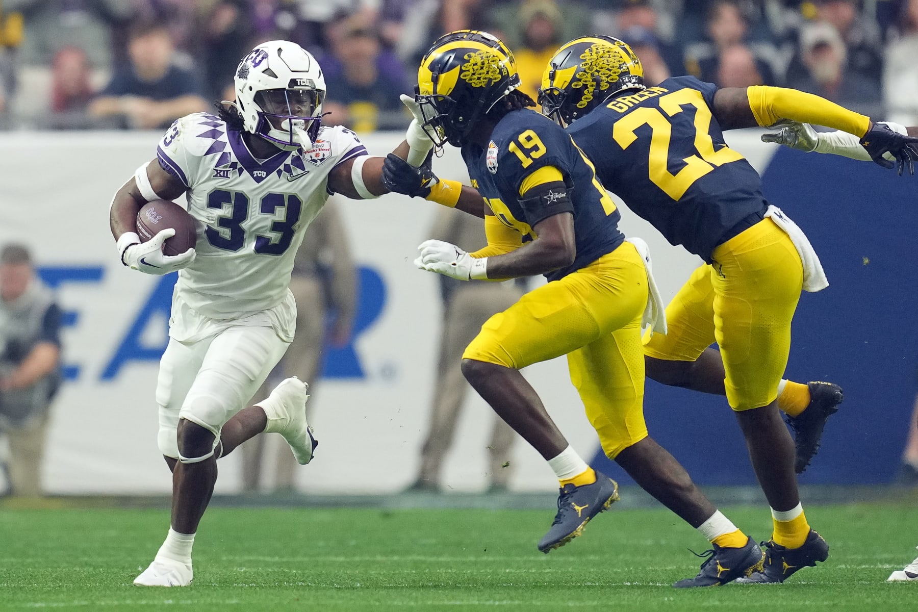 GLENDALE, AZ - DECEMBER 31: TCU Horned Frogs running back Kendre Miller (33) battles with Michigan Wolverines defensive back Rod Moore (19) in action during a the Vrbo Fiesta Bow game between the Texas Christian Horned Frogs and the Michigan Wolverines on December 31st, 2022, at State Farm Stadium in Glendale, AZ.  (Photo by Robin Alam/Icon Sportswire via Getty Images)
