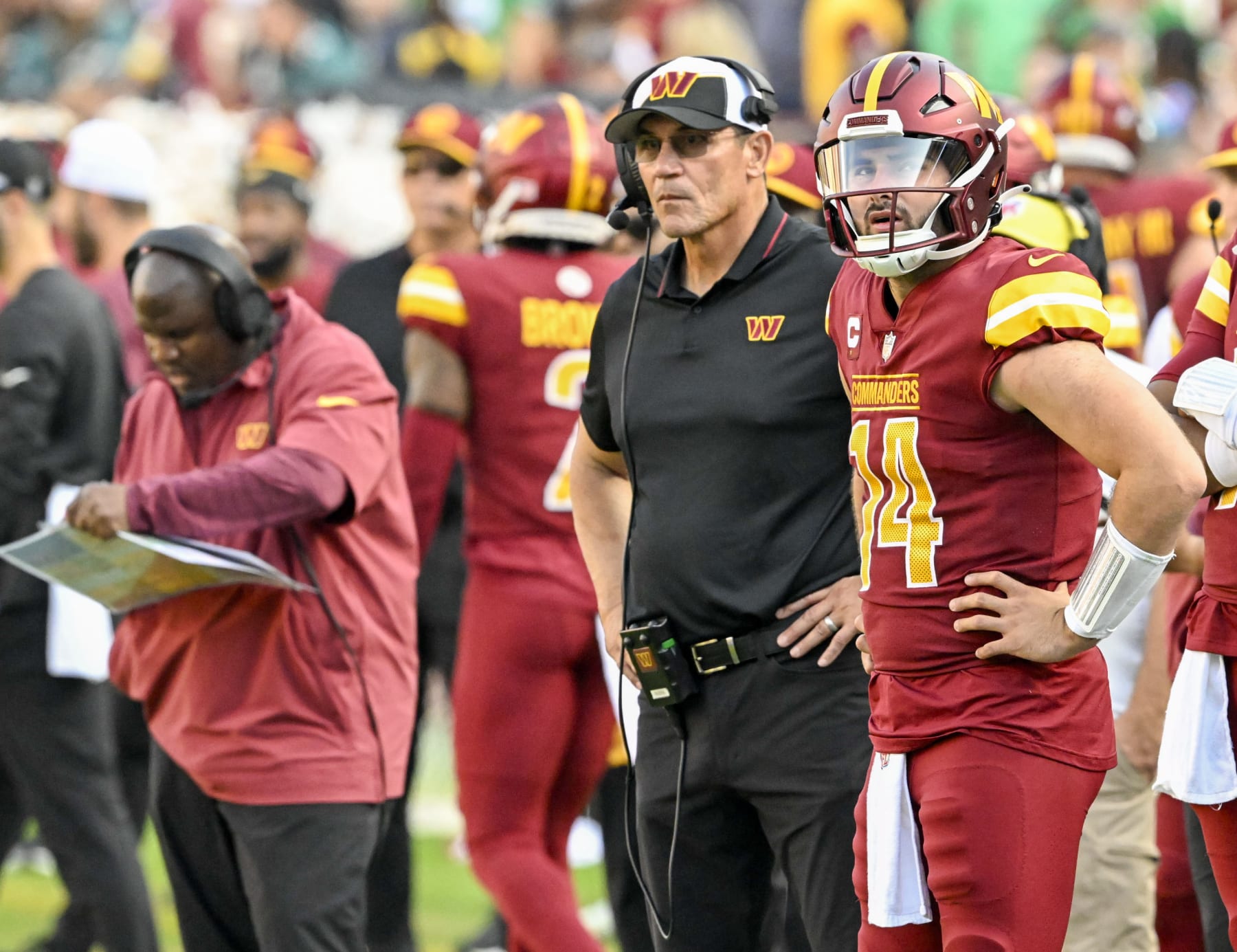 LANDOVER, MD -OCTOBER 29: Washington Commanders quarterback Sam Howell (14) looks on during fourth quarter action along with head coach Ron Rivera and offensive coordinator Bieniemy during action against the Philadelphia Eagles at FedEx Field on October 29, 2023. (Photo by Jonathan Newton/The Washington Post via Getty Images)
