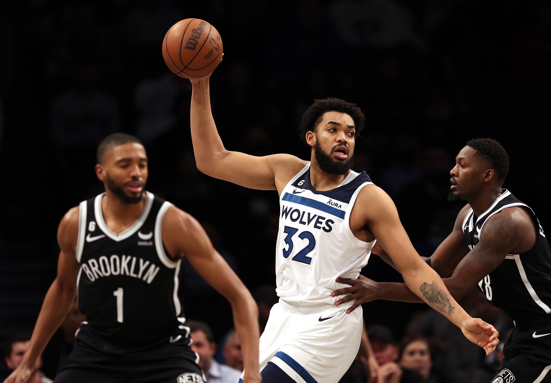 NEW YORK, NEW YORK - APRIL 04:  Karl-Anthony Towns #32 of the Minnesota Timberwolves controls the ball as Mikal Bridges #1 and Dorian Finney-Smith #28 of the Brooklyn Nets defend during the game at Barclays Center on April 04, 2023 in New York City. (Photo by Jamie Squire/Getty Images)