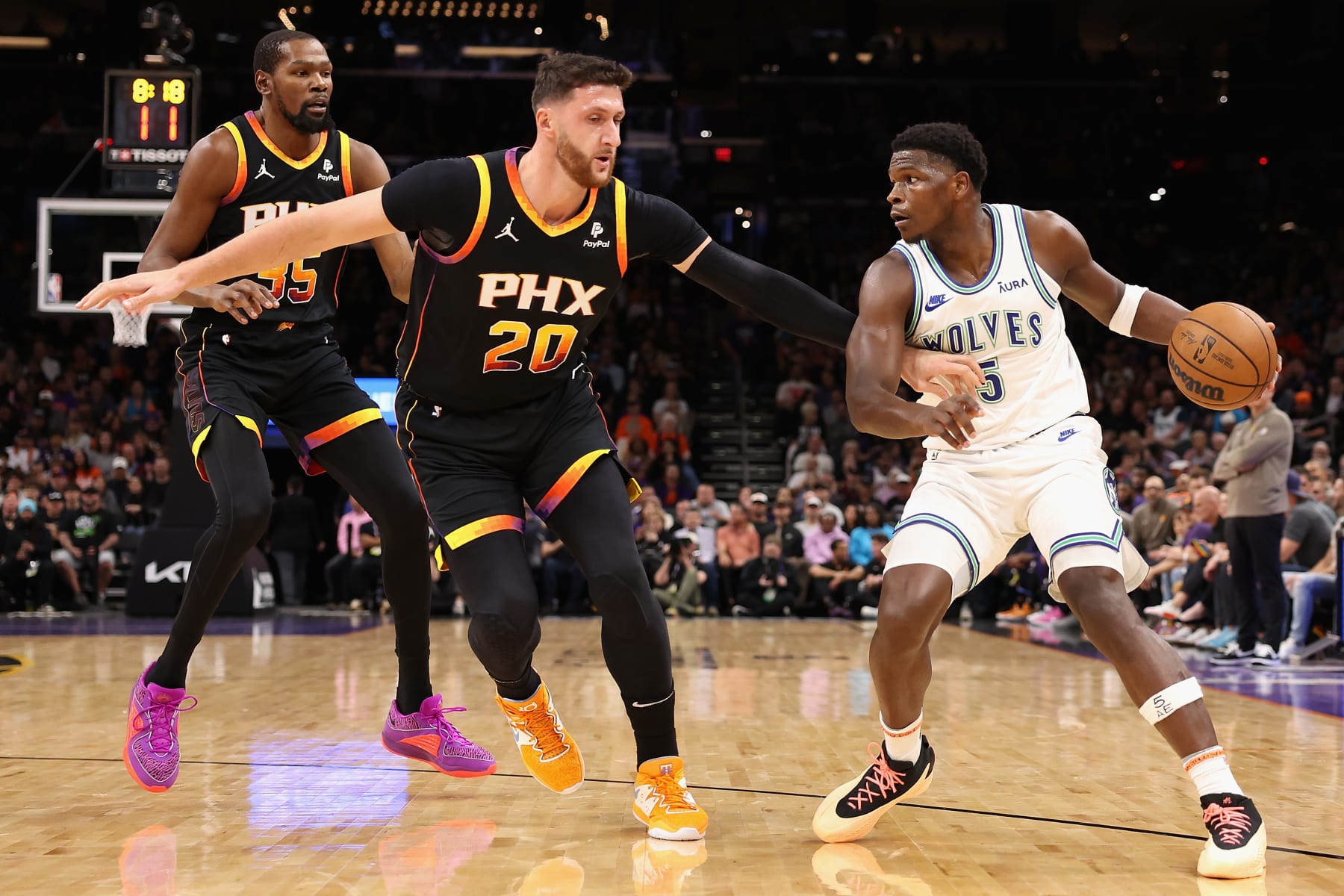 PHOENIX, ARIZONA - NOVEMBER 15: Anthony Edwards #5 of the Minnesota Timberwolves handles the ball against Jusuf Nurkic #20 and Kevin Durant #35 of the Phoenix Suns during the first half of the NBA game at Footprint Center on November 15, 2023 in Phoenix, Arizona. NOTE TO USER: User expressly acknowledges and agrees that, by downloading and or using this photograph, User is consenting to the terms and conditions of the Getty Images License Agreement.  (Photo by Christian Petersen/Getty Images)