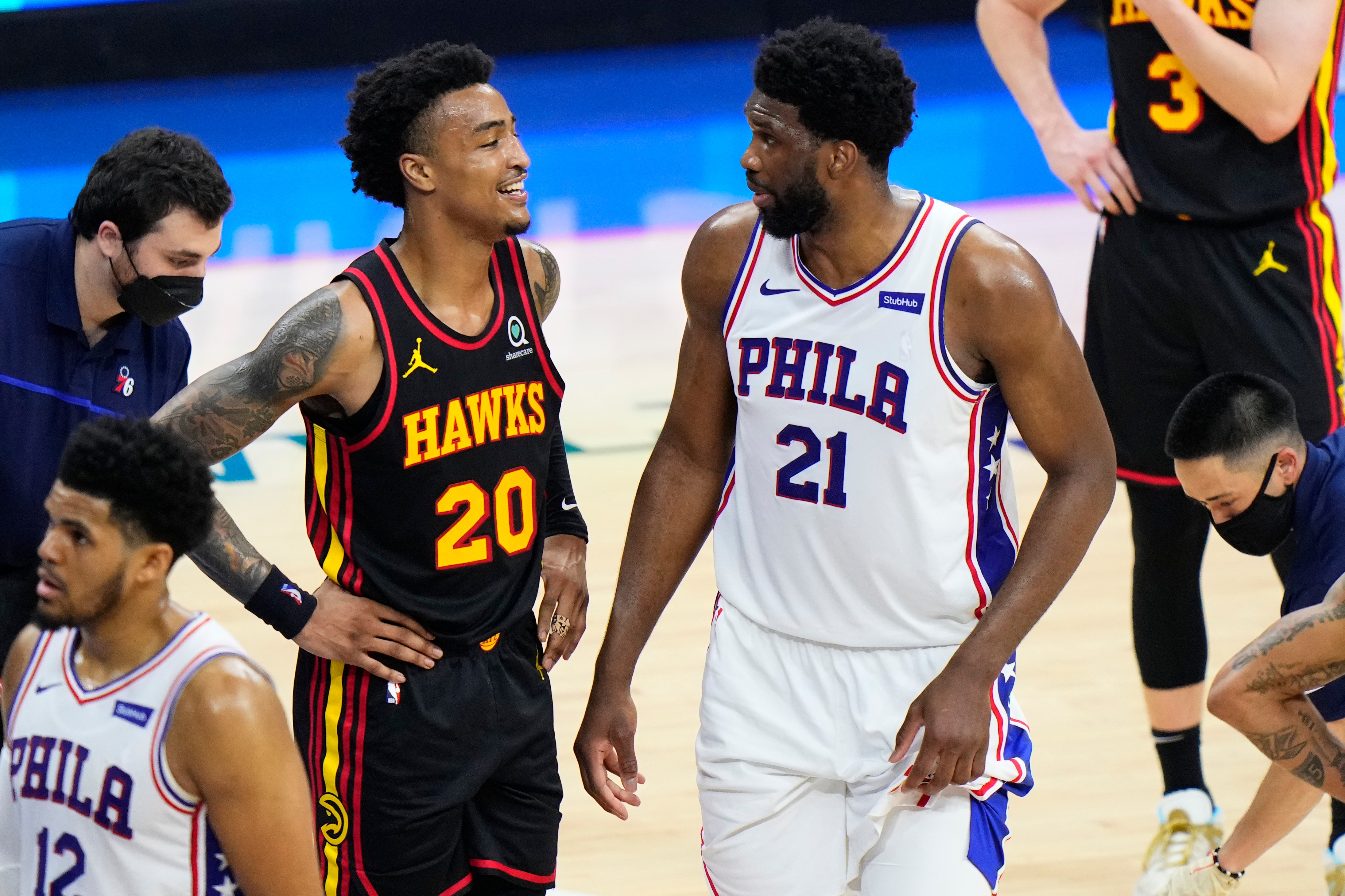 Atlanta Hawks' John Collins, left, and Philadelphia 76ers' Joel Embiid talk during the first half of Game 7 in a second-round NBA basketball playoff series, Sunday, June 20, 2021, in Philadelphia. (AP Photo/Matt Slocum)