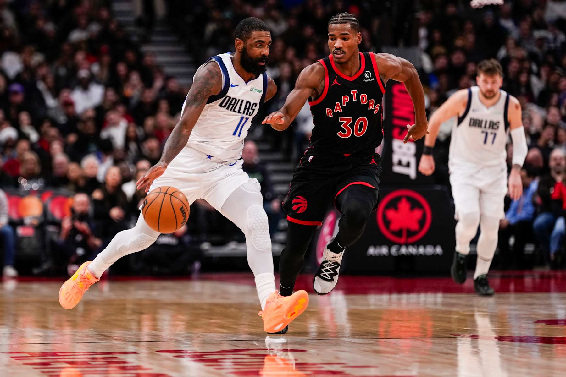 TORONTO, ON - DECEMBER 7: Kyrie Irving #11 of the Dallas Mavericks dribbles the ball against Ochai Agbaji #30 of the Toronto Raptors at Scotiabank Arena on December 7, 2024 in Toronto, Ontario, Canada. NOTE TO USER: User expressly acknowledges and agrees that, by downloading and/or using this Photograph, user is consenting to the terms and conditions of the Getty Images License Agreement. (Photo by Andrew Lahodynskyj/Getty Images)