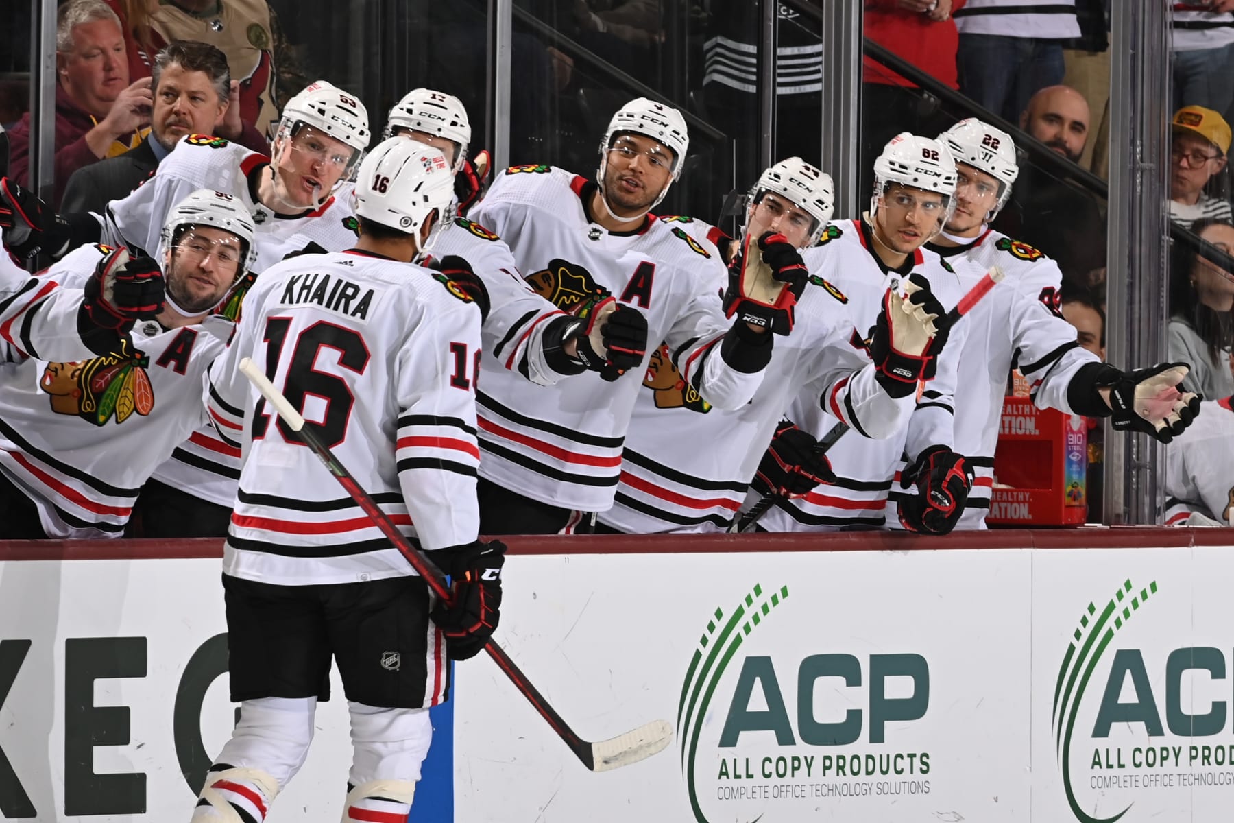 TEMPE, ARIZONA - MARCH 18: Jujhar Khaira #16 of the Chicago Blackhawks celebrates with teammates on the bench after scoring a goal against the Arizona Coyotes during the first period at Mullett Arena on March 18, 2023 in Tempe, Arizona. (Photo by Norm Hall/NHLI via Getty Images)