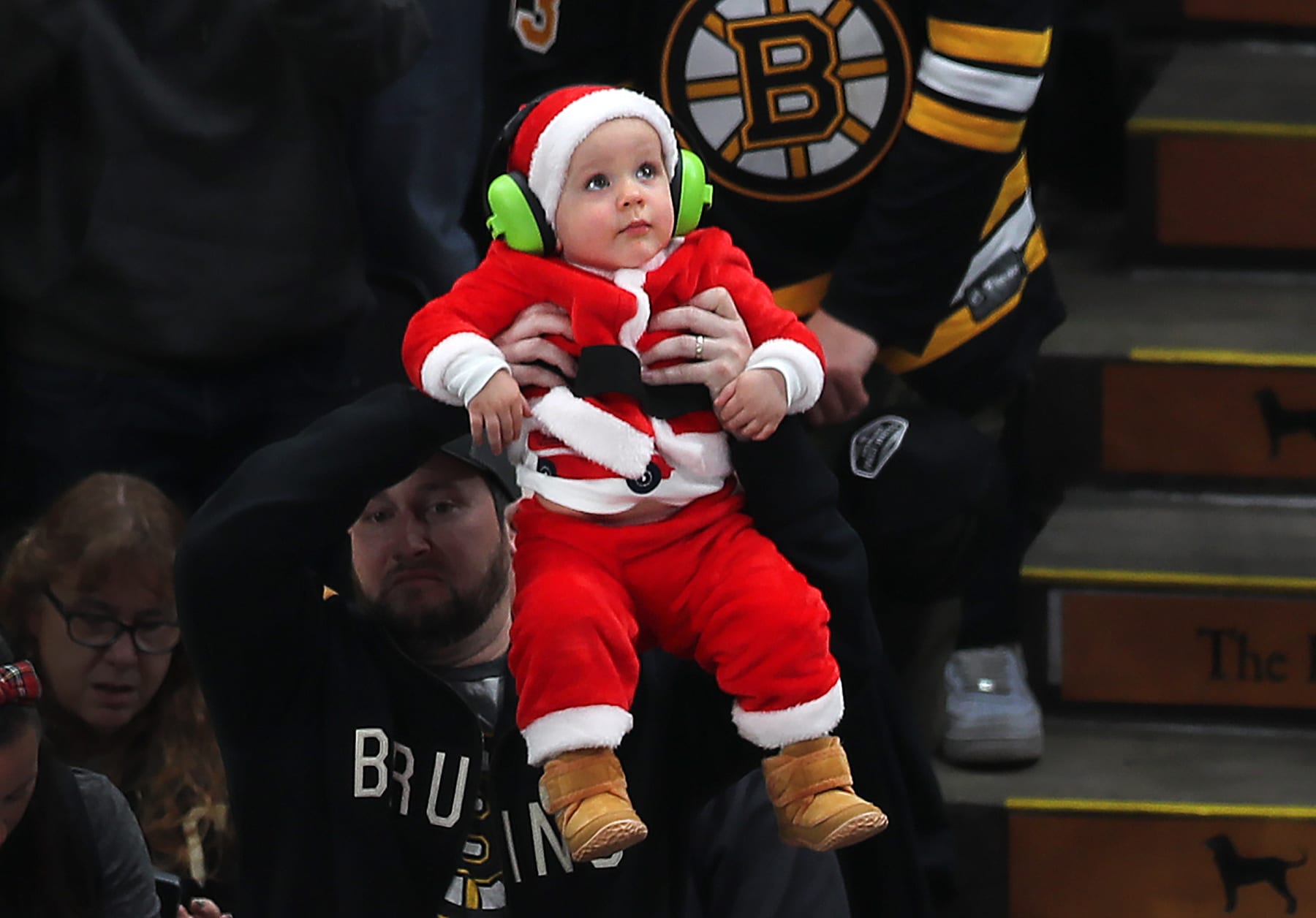 Boston, MA - December 9: A young fan in a Santa costume is held aloft in the second period. The Boston Bruins beat the Arizona Coyotes, 5-3. (Photo by John Tlumacki/The Boston Globe via Getty Images)