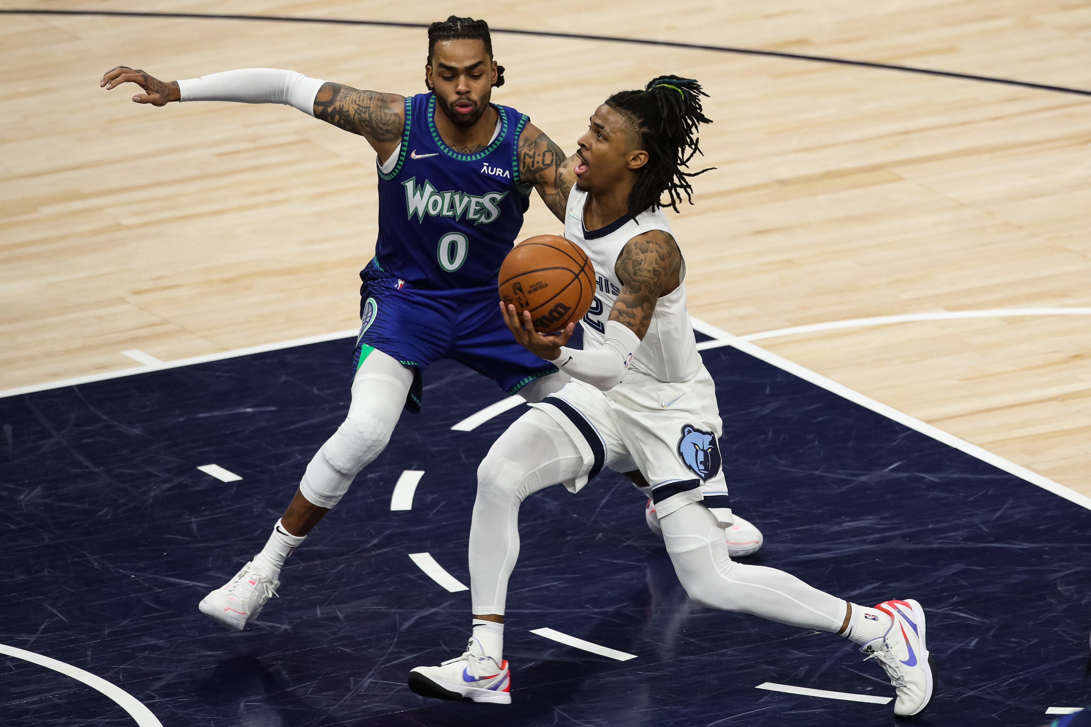 MINNEAPOLIS, MN - APRIL 21: Ja Morant #12 of the Memphis Grizzlies drives to the basket while D'Angelo Russell #0 of the Minnesota Timberwolves defend in the second quarter of the game during Game Three of the Western Conference First Round at Target Center on April 21, 2022 in Minneapolis, Minnesota. The Grizzlies defeated the Timberwolves 104-95. NOTE TO USER: User expressly acknowledges and agrees that, by downloading and or using this Photograph, user is consenting to the terms and conditions of the Getty Images License Agreement. (Photo by David Berding/Getty Images)