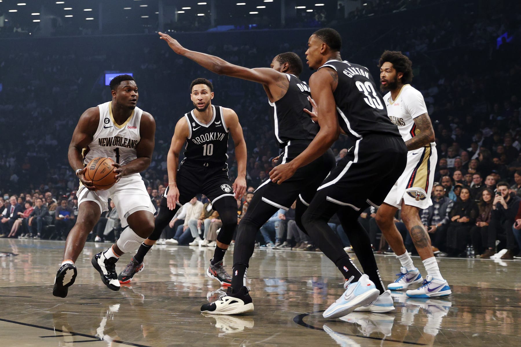 NEW YORK, NEW YORK - OCTOBER 19: Zion Williamson #1 of the New Orleans Pelicans dribbles as Ben Simmons #10, Kevin Durant #7, and Nic Claxton #33 of the Brooklyn Nets defend during the first half at Barclays Center on October 19, 2022 in the Brooklyn borough of New York City. NOTE TO USER: User expressly acknowledges and agrees that, by downloading and or using this photograph, User is consenting to the terms and conditions of the Getty Images License Agreement. (Photo by Sarah Stier/Getty Images)