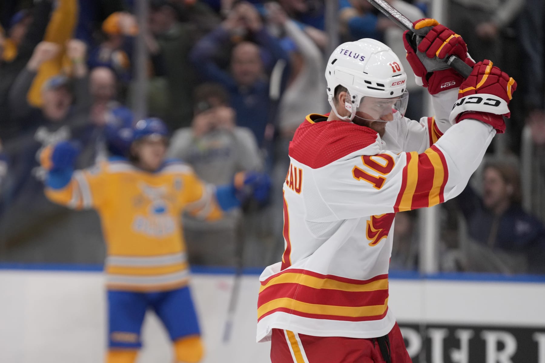 Calgary Flames' Jonathan Huberdeau (10) reacts after St. Louis Blues' Robert Thomas, left, scored during overtime of an NHL hockey game Tuesday, Jan. 10, 2023, in St. Louis. The Blues won 4-3. (AP Photo/Jeff Roberson)