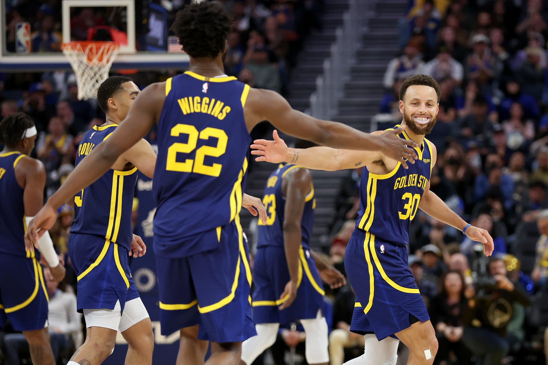SAN FRANCISCO, CALIFORNIA - DECEMBER 03: Stephen Curry #30 of the Golden State Warriors high-fives Andrew Wiggins #22 as he walks back to the bench during the fourth quarter of their game against the Houston Rockets at Chase Center on December 03, 2022 in San Francisco, California. NOTE TO USER: User expressly acknowledges and agrees that, by downloading and or using this photograph, User is consenting to the terms and conditions of the Getty Images License Agreement.  (Photo by Ezra Shaw/Getty Images)