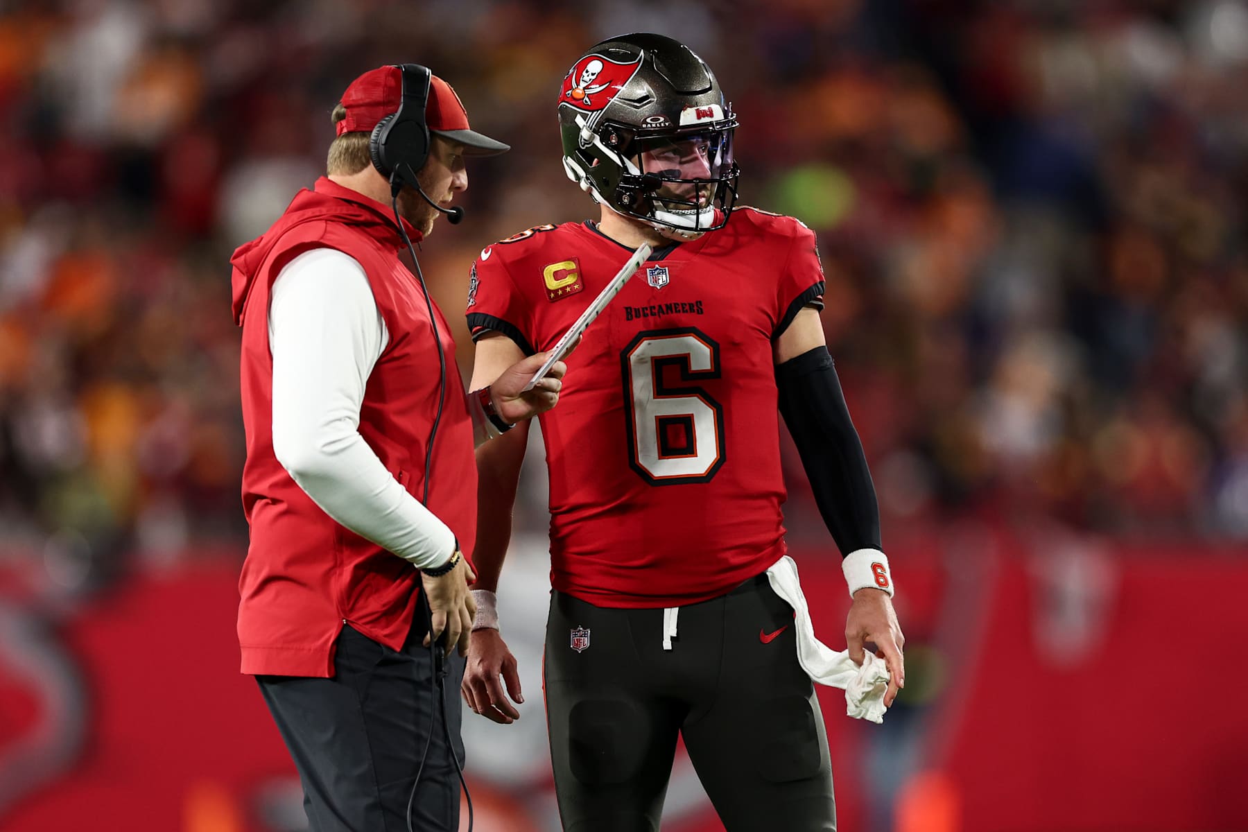 TAMPA, FLORIDA - JANUARY 12: Baker Mayfield #6 of the Tampa Bay Buccaneers talks with offensive coordinator Liam Coen during the first half of an NFL football wild card playoff game against the Washington Commanders at Raymond James Stadium on January 12, 2025 in Tampa, Florida. (Photo by Kevin Sabitus/Getty Images)