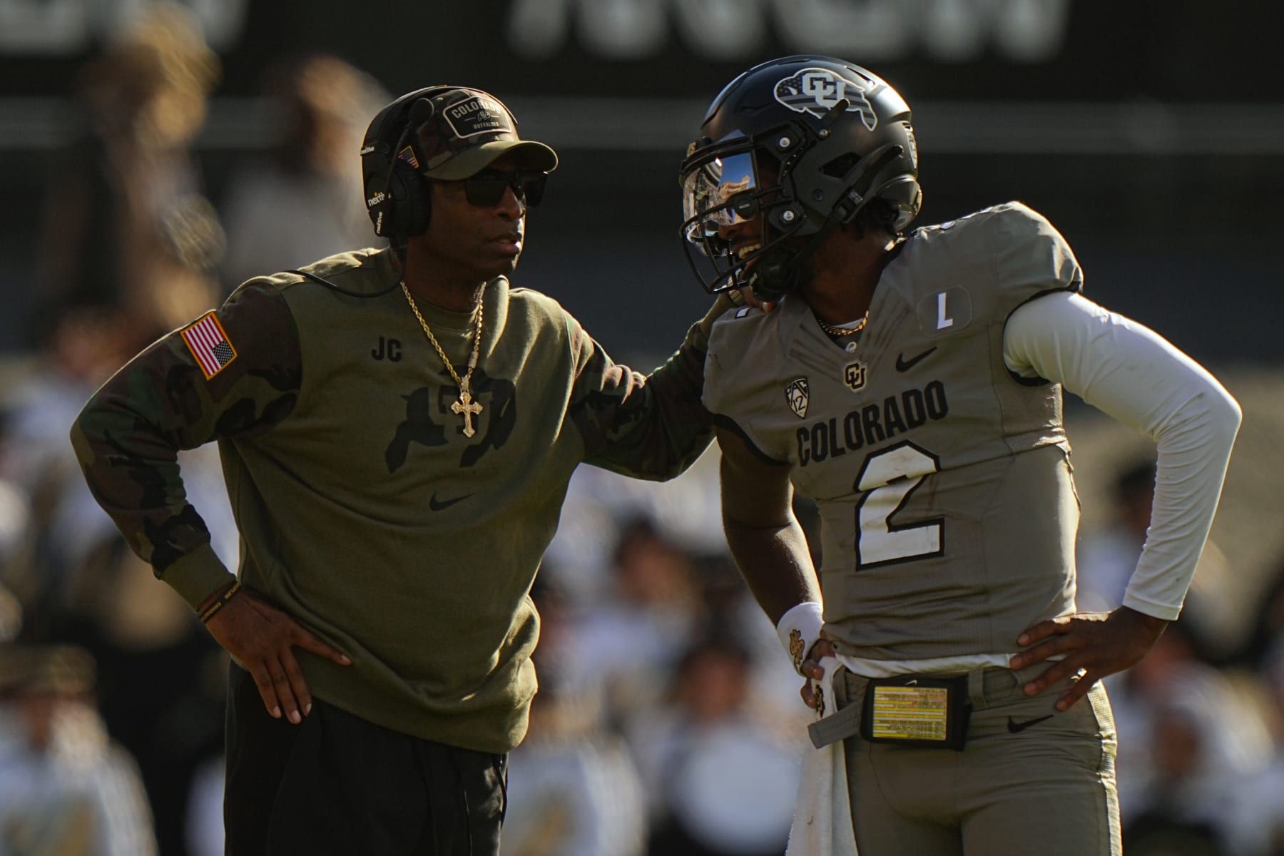 Colorado head coach Deion Sanders talks with quarterback Shedeur Sanders 