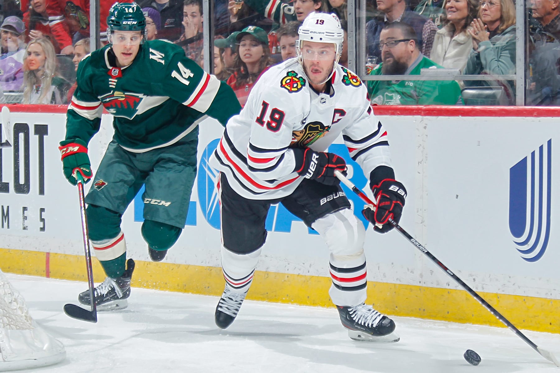SAINT PAUL, MN - MARCH 19: Jonathan Toews #19 of the Chicago Blackhawks skates with the puck while Joel Eriksson Ek #14 of the Minnesota Wild defends during the game at the Xcel Energy Center on March 19, 2022 in Saint Paul, Minnesota. (Photo by Bruce Kluckhohn/NHLI via Getty Images)