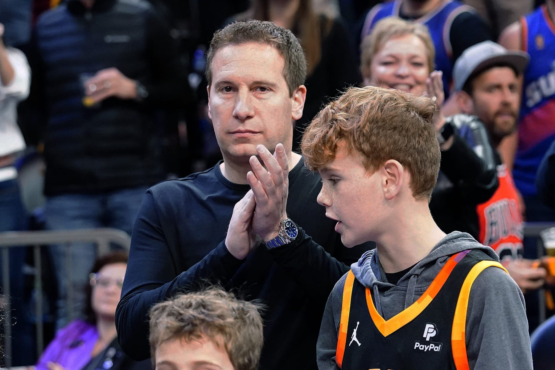 Incoming Phoenix Suns owner Mat Ishbia claps as the 1993 Suns team is introduced during halftime of ah NBA basketball game between the Suns and the Indiana Pacers in Phoenix, Saturday, Jan. 21, 2023. (AP Photo/Darryl Webb)