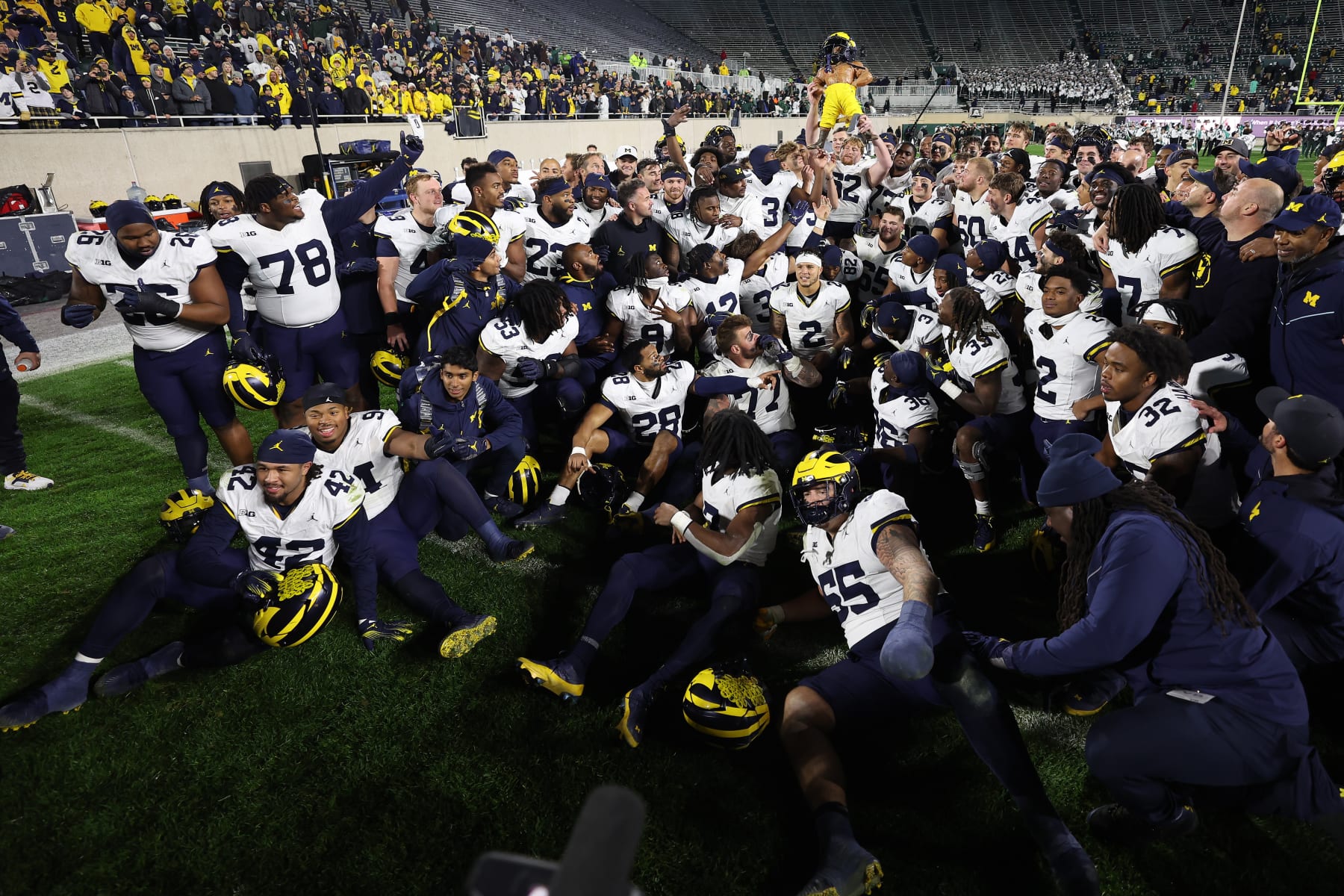 EAST LANSING, MICHIGAN - OCTOBER 21: The Michigan Wolverines celebrate with the Paul Bunyan trophy after a 49-0 win over the Michigan State Spartans at Spartan Stadium on October 21, 2023 in East Lansing, Michigan. (Photo by Gregory Shamus/Getty Images)