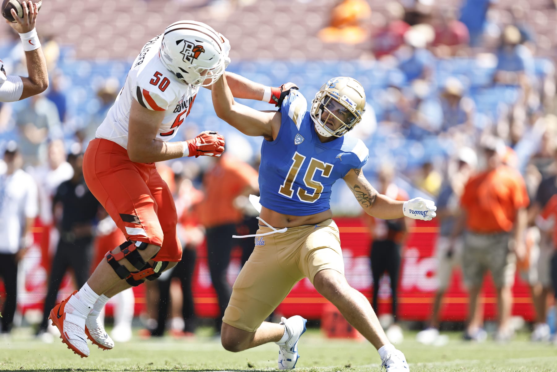 PASADENA, CALIFORNIA - SEPTEMBER 03: Laiatu Latu #15 of the UCLA Bruins rushes against Alex Wollschlaeger #50 of the Bowling Green Falcons during game between the UCLA Bruins and the Bowling Green Falcons at Rose Bowl on September 03, 2022 in Pasadena, California. (Photo by Michael Owens/Getty Images)