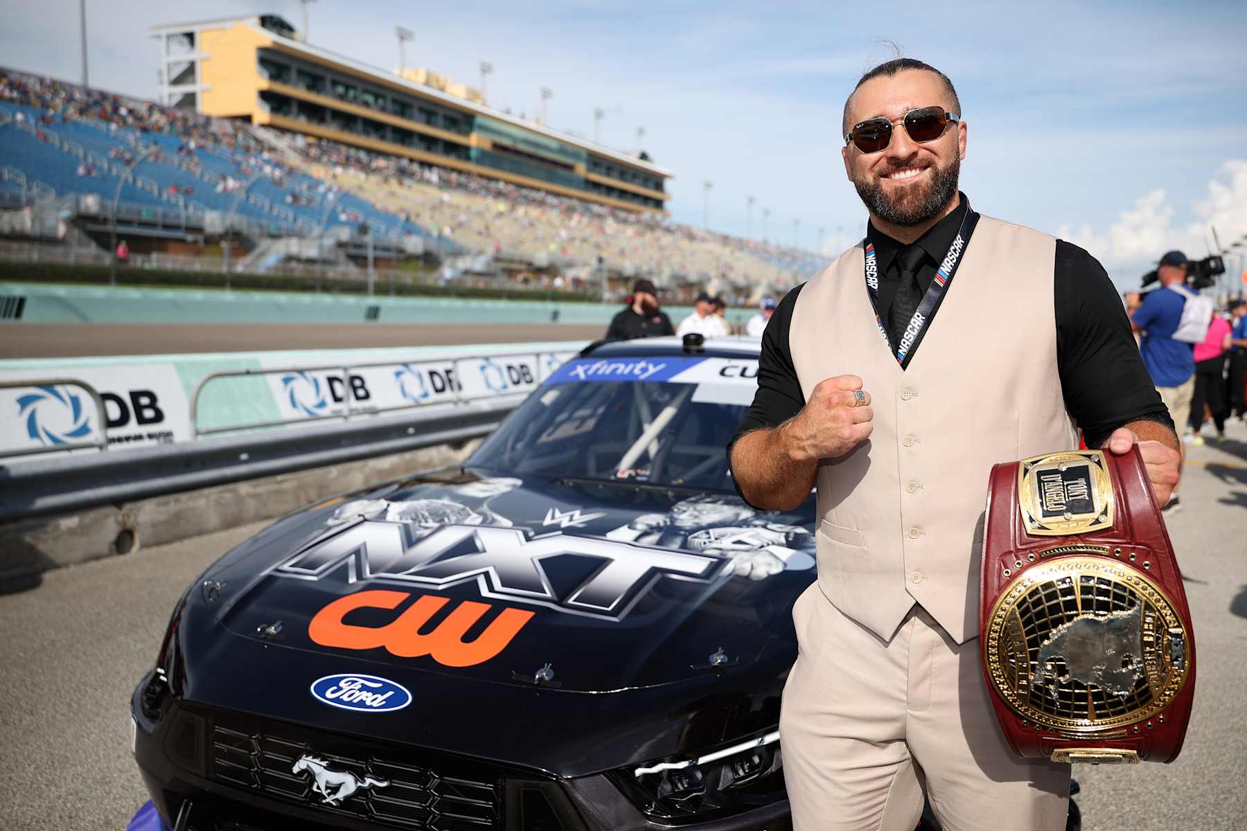 HOMESTEAD, FLORIDA - OCTOBER 26: WWE NXT star, Tony D'Angelo poses with the #00 NXT on CW Ford, driven by Cole Custer on the grid prior to the NASCAR Xfinity Series Credit One NASCAR Amex Credit 300 at Homestead-Miami Speedway on October 26, 2024 in Homestead, Florida. (Photo by James Gilbert/Getty Images)