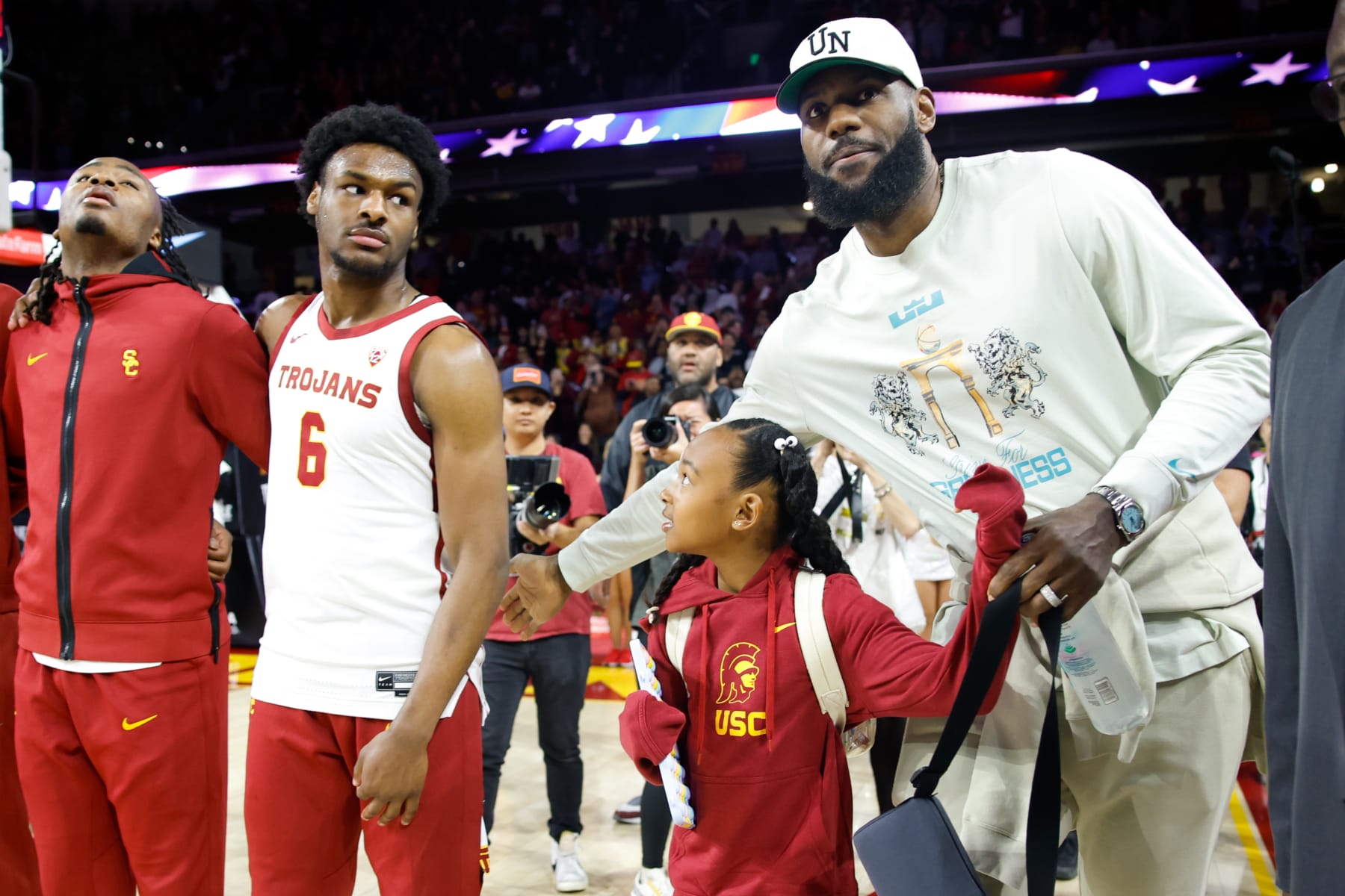 Los Angeles, CA - December 10: Lakers' LeBron James, right, pats the back of USC Trojans guard Bronny James (6) before the game against the Long Beach State 49ers at Galen Center in Los Angeles Sunday, Dec. 10, 2023.  (Jason Armond / Los Angeles Times via Getty Images)