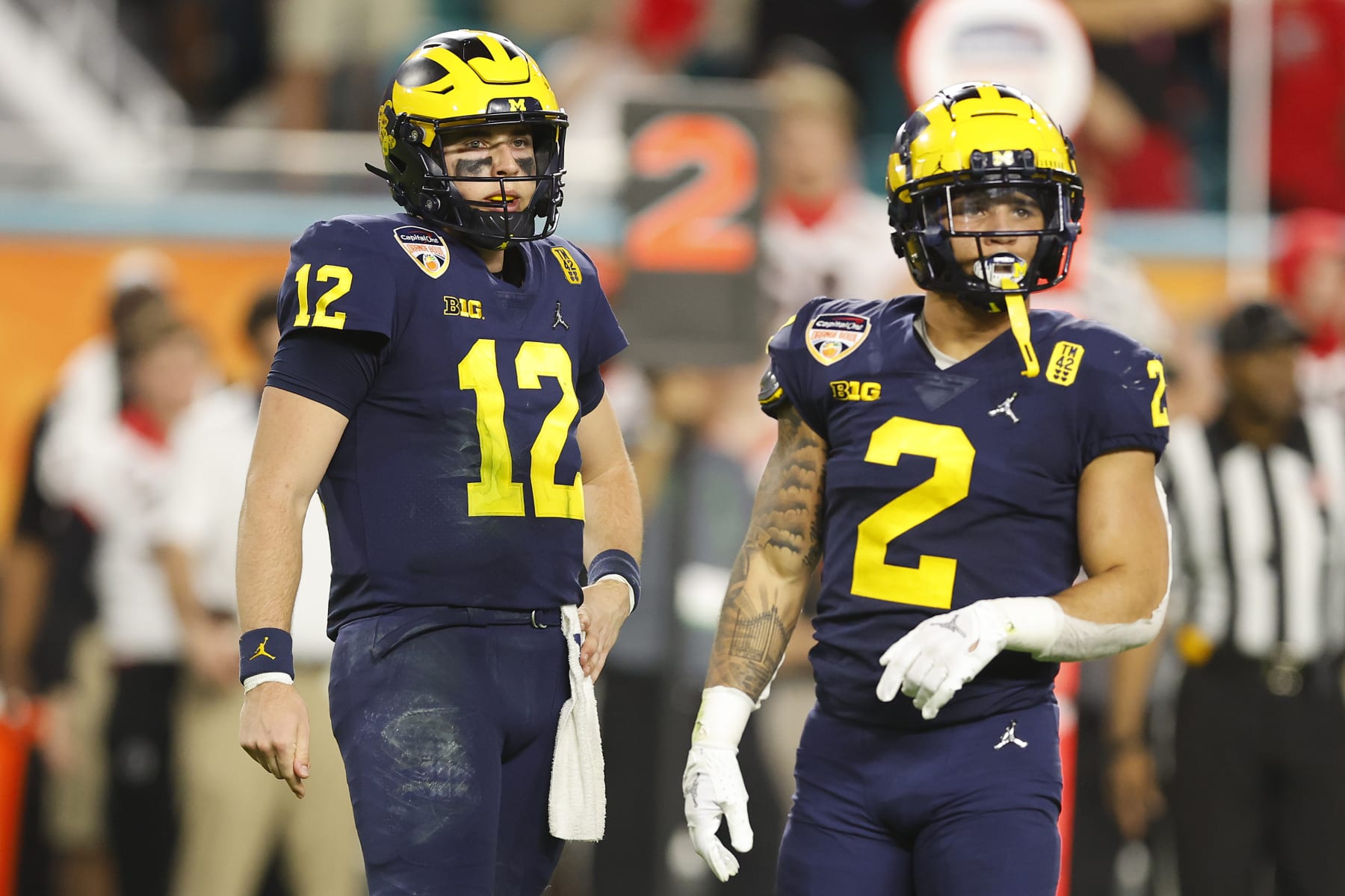 MIAMI GARDENS, FLORIDA - DECEMBER 31: Cade McNamara #12 and Blake Corum #2 of the Michigan Wolverines look on against the Georgia Bulldogs in the Capital One Orange Bowl for the College Football Playoff semifinal game at Hard Rock Stadium on December 31, 2021 in Miami Gardens, Florida. (Photo by Michael Reaves/Getty Images)