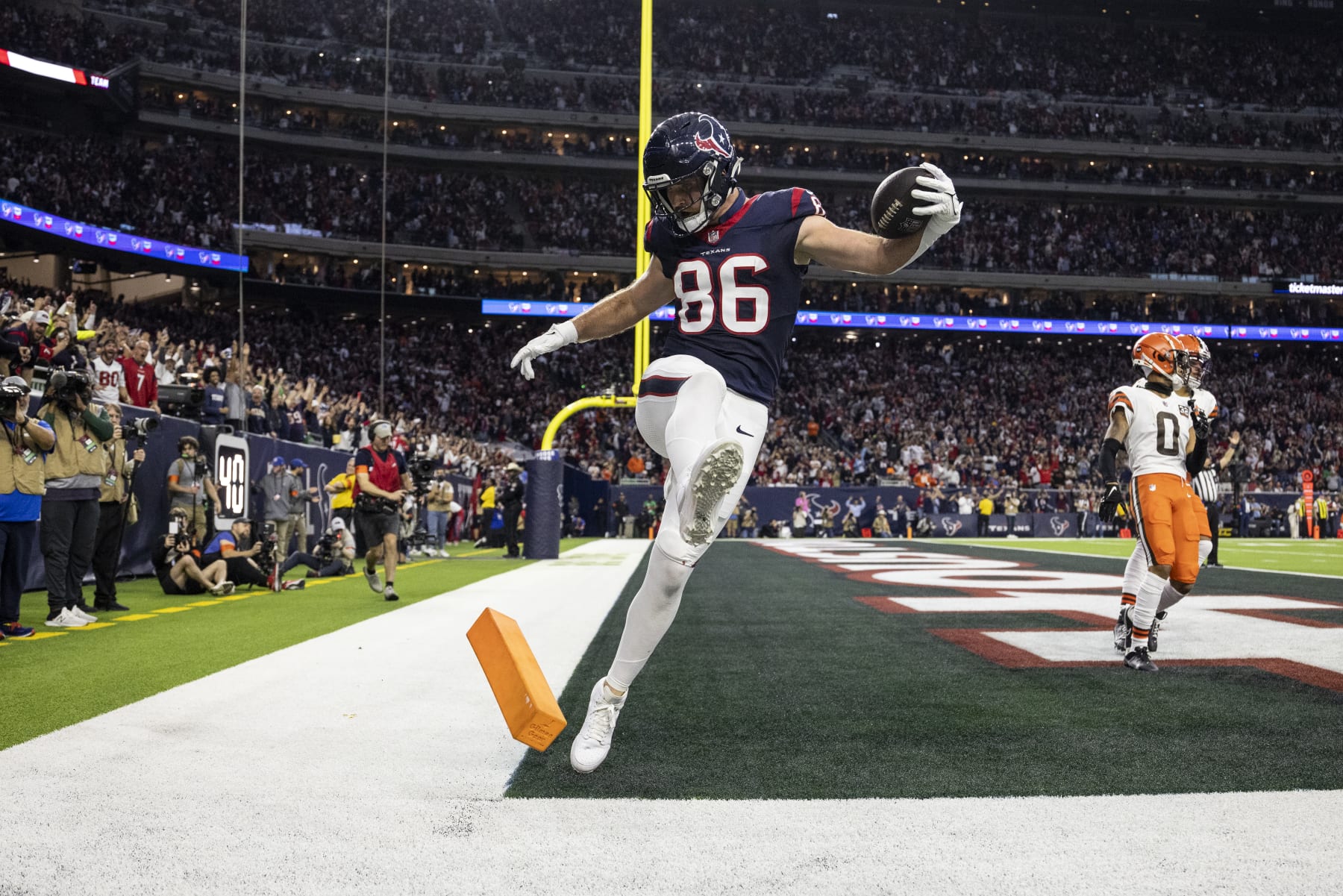 HOUSTON, TEXAS - JANUARY 13: Dalton Schultz #86 of the Houston Texans celebrates by kicking the pylon after completing a pass for a touchdown during an NFL wild-card playoff football game between the Houston Texans and the Cleveland Browns at NRG Stadium on January 13, 2024 in Houston, Texas. (Photo by Michael Owens/Getty Images)