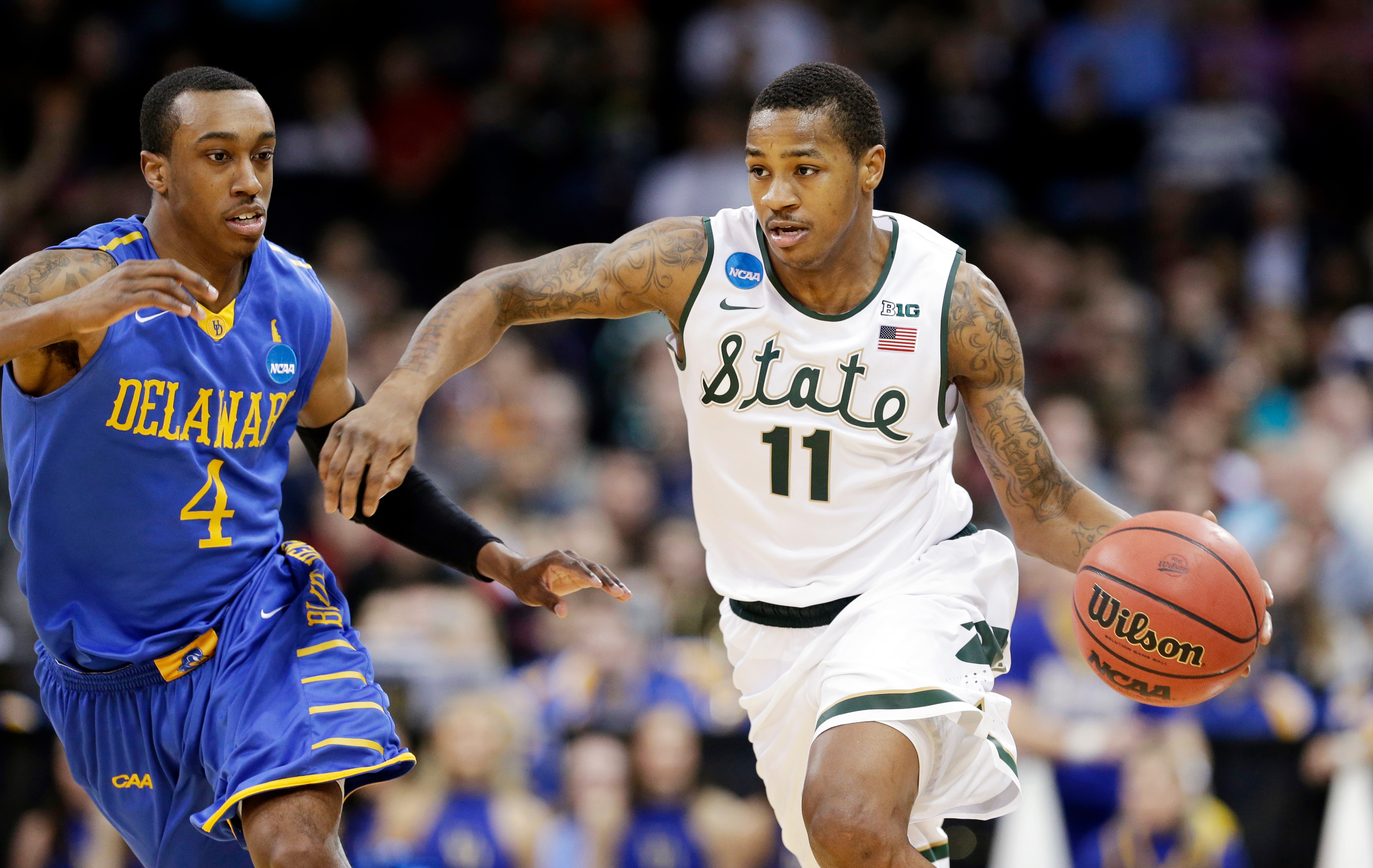 Michigan State's Keith Appling (11) drives in front of Delaware's Jarvis Threatt in the second half during the second round of the NCAA college basketball tournament in Spokane, Wash., Thursday, March 20, 2014. Michigan State won 93-78. (AP Photo/Elaine Thompson)