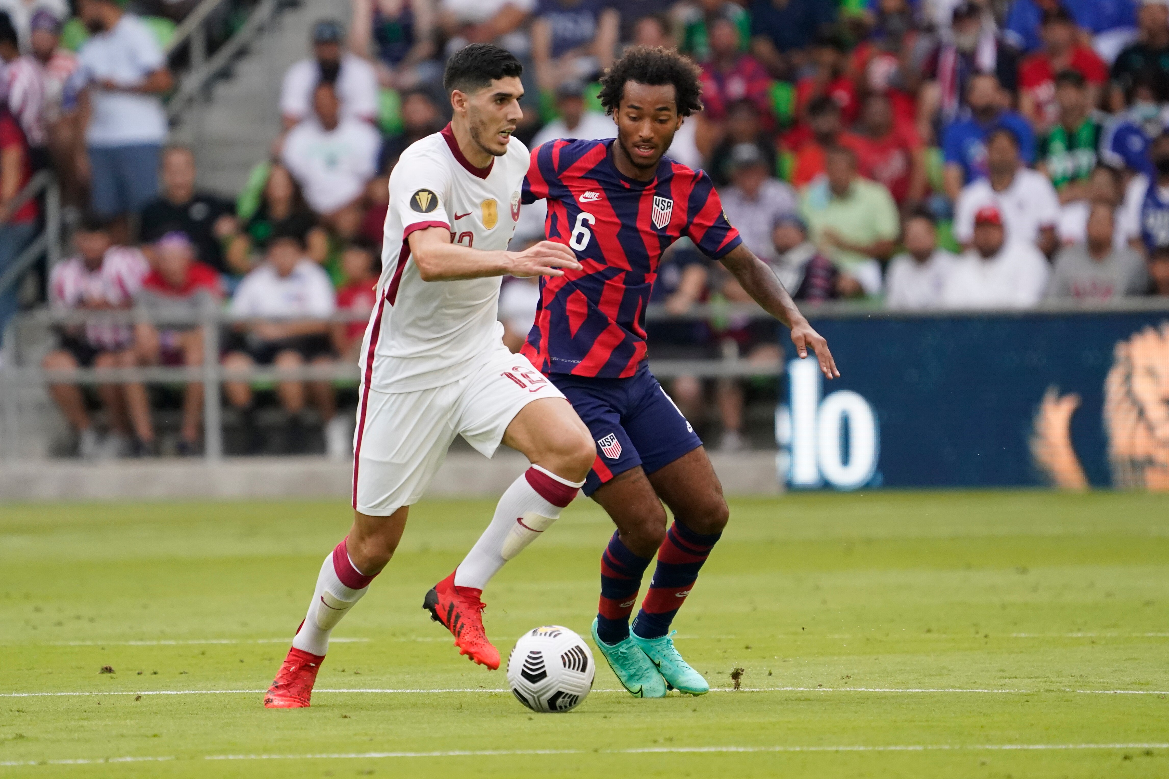 AUSTIN, TX - JULY 29: Karim Boudiaf #12 of Qatar drives against Gianluca Busio #6 of the United States during the first half of a 2021 CONCACAF Gold Cup Semifinals match at Q2 Stadium on July 29, 2021 in Austin, Texas. (Photo by Chuck Burton/Getty Images)
