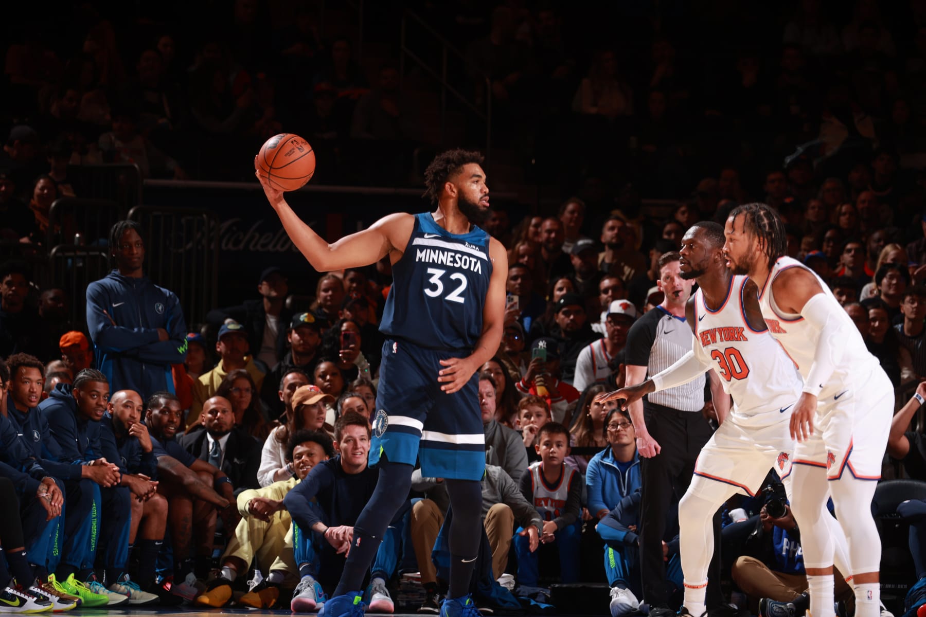 NEW YORK, NY - OCTOBER 14: Karl-Anthony Towns #32 of the Minnesota Timberwolves handles the ball against defenders Julius Randle #30 and Jalen Brunson #11 of the New York Knicks during the preseason game on October 14, 2023 at Madison Square Garden in New York City, New York.  NOTE TO USER: User expressly acknowledges and agrees that, by downloading and or using this photograph, User is consenting to the terms and conditions of the Getty Images License Agreement. Mandatory Copyright Notice: Copyright 2023 NBAE  (Photo by Nathaniel S. Butler/NBAE via Getty Images)