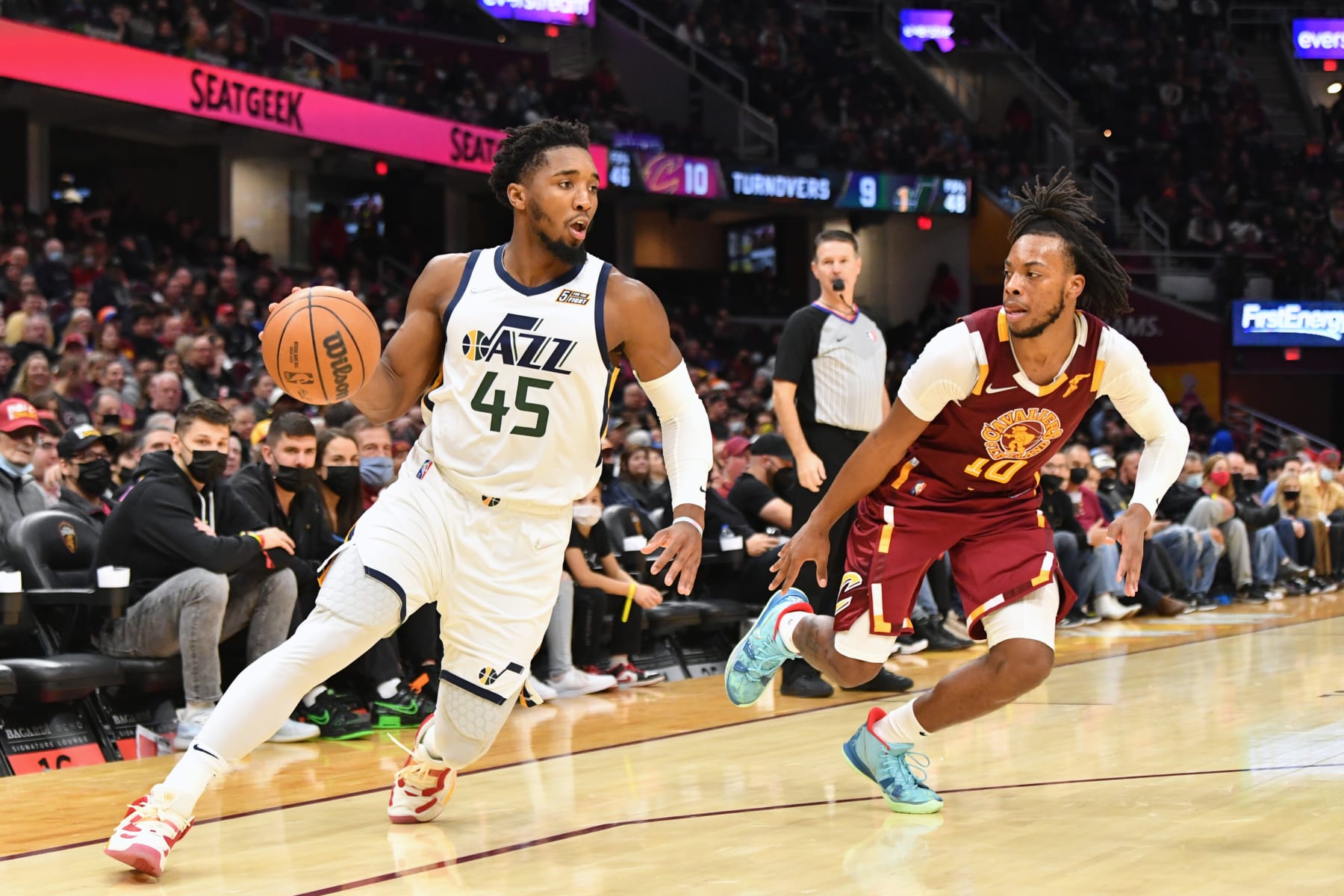 CLEVELAND, OHIO - DECEMBER 05: Donovan Mitchell #45 of the Utah Jazz drives to the basket around Darius Garland #10 of the Cleveland Cavaliers during the third quarter at Rocket Mortgage Fieldhouse on December 05, 2021 in Cleveland, Ohio. The Jazz defeated the Cavaliers 109-108. NOTE TO USER: User expressly acknowledges and agrees that, by downloading and/or using this photograph, user is consenting to the terms and conditions of the Getty Images License Agreement. (Photo by Jason Miller/Getty Images)