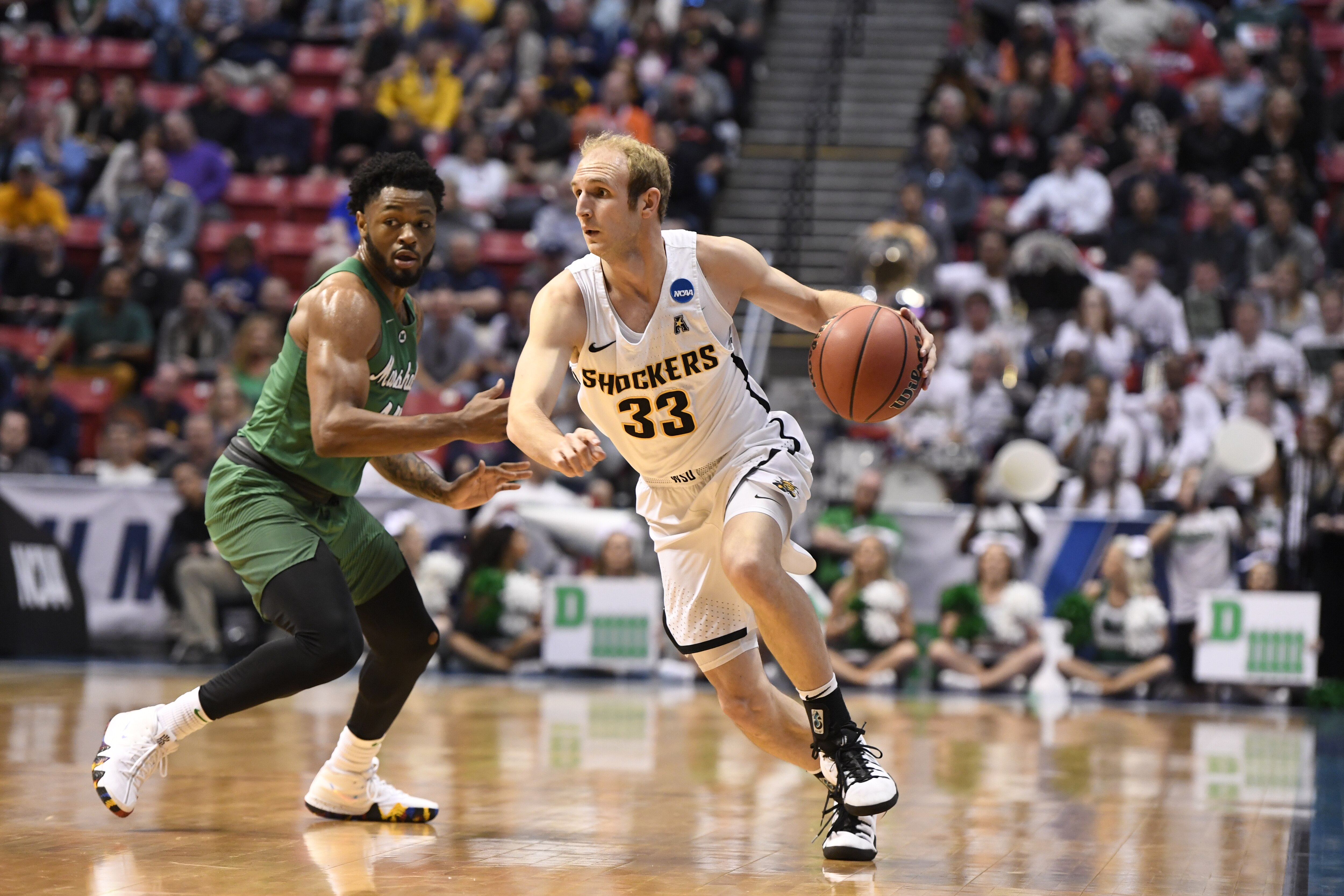 SAN DIEGO, CA - MARCH 16: Conner Frankamp #33 of The Wichita State Shockers drives to the basket against C.J. Burks #14 of the Marshall Thundering Herd in the first round of the 2018 NCAA Photos via Getty Images Men's Basketball Tournament held at Viejas Arena on March 16, 2018 in San Diego, California. (Photo by Jamie Schwaberow/NCAA Photos via Getty Images)