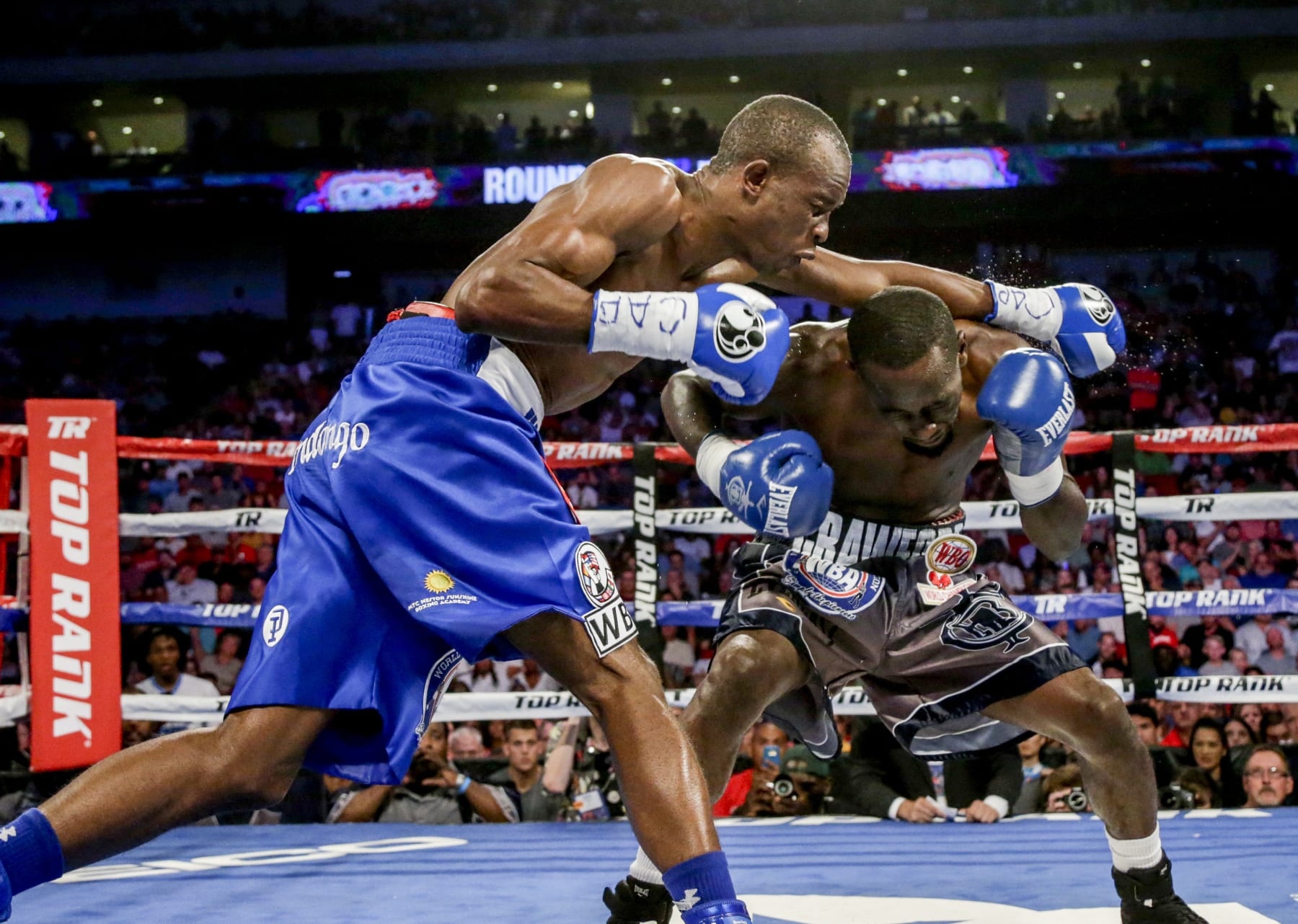 Terence "Bud" Crawford, right, ducks under a punch by Julius Indongo in a junior welterweight world title unification bout in Lincoln, Neb., Saturday, Aug. 19, 2017. Crawford won by knockout in the third round and now holds the WBO, WBC, IBF and WBA 140 pound world titles. It was only the second fight in the four-belt era in which all four titles were on the line. (AP Photo/Nati Harnik)