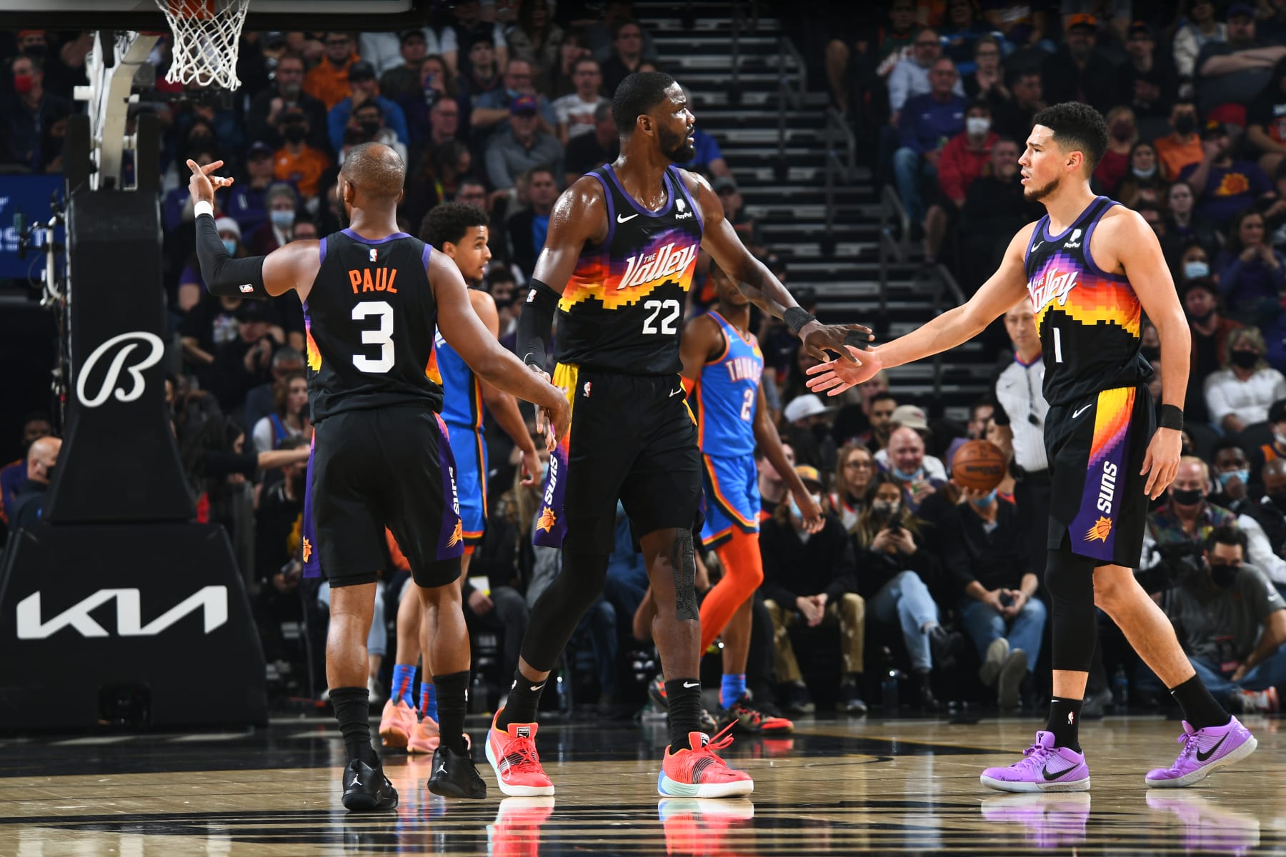 PHOENIX, AZ - DECEMBER 23: Deandre Ayton #22 of the Phoenix Suns embraces with Chris Paul #3 and Devin Booker #1 during the game against the Oklahoma City Thunder on December 23, 2021 at Footprint Center in Phoenix, Arizona. NOTE TO USER: User expressly acknowledges and agrees that, by downloading and or using this photograph, user is consenting to the terms and conditions of the Getty Images License Agreement. Mandatory Copyright Notice: Copyright 2021 NBAE (Photo by Michael Gonzales/NBAE via Getty Images)