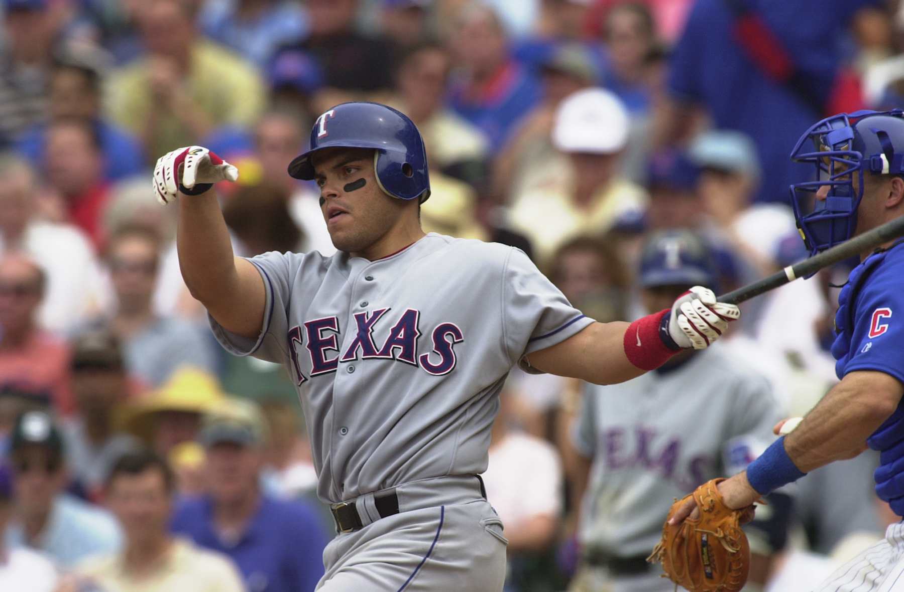 CHICAGO - JUNE 19:  Catcher Ivan Rodriguez #7 of the Texas Rangers eyes his batted ball as he follows through against the Chicago Cubs during the MLB game at Wrigley Field in Chicago, Illinois on June 19, 2002.  The Rangers defeated the Cubs 7-4.  (Photo by Jonathan Daniel/Getty Images)
