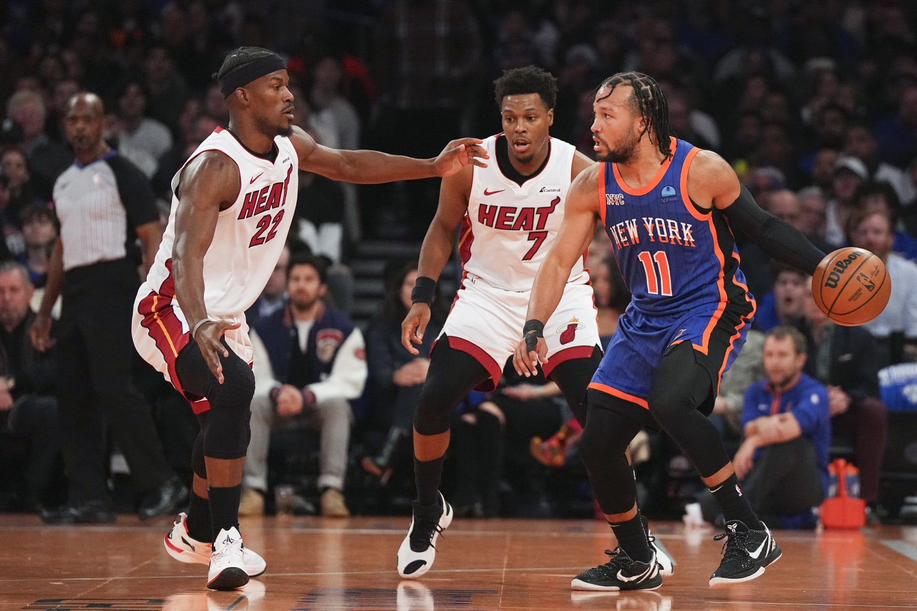 NEW YORK, NEW YORK - NOVEMBER 24: Jalen Brunson #11 of the New York Knicks dribbles the ball against Jimmy Butler #22 and Kyle Lowry #7 of the Miami Heat in the first half during the NBA In-Season Tournament at Madison Square Garden on November 24, 2023 in New York City. NOTE TO USER: User expressly acknowledges and agrees that, by downloading and or using this photograph, User is consenting to the terms and conditions of the Getty Images License Agreement. (Photo by Mitchell Leff/Getty Images)