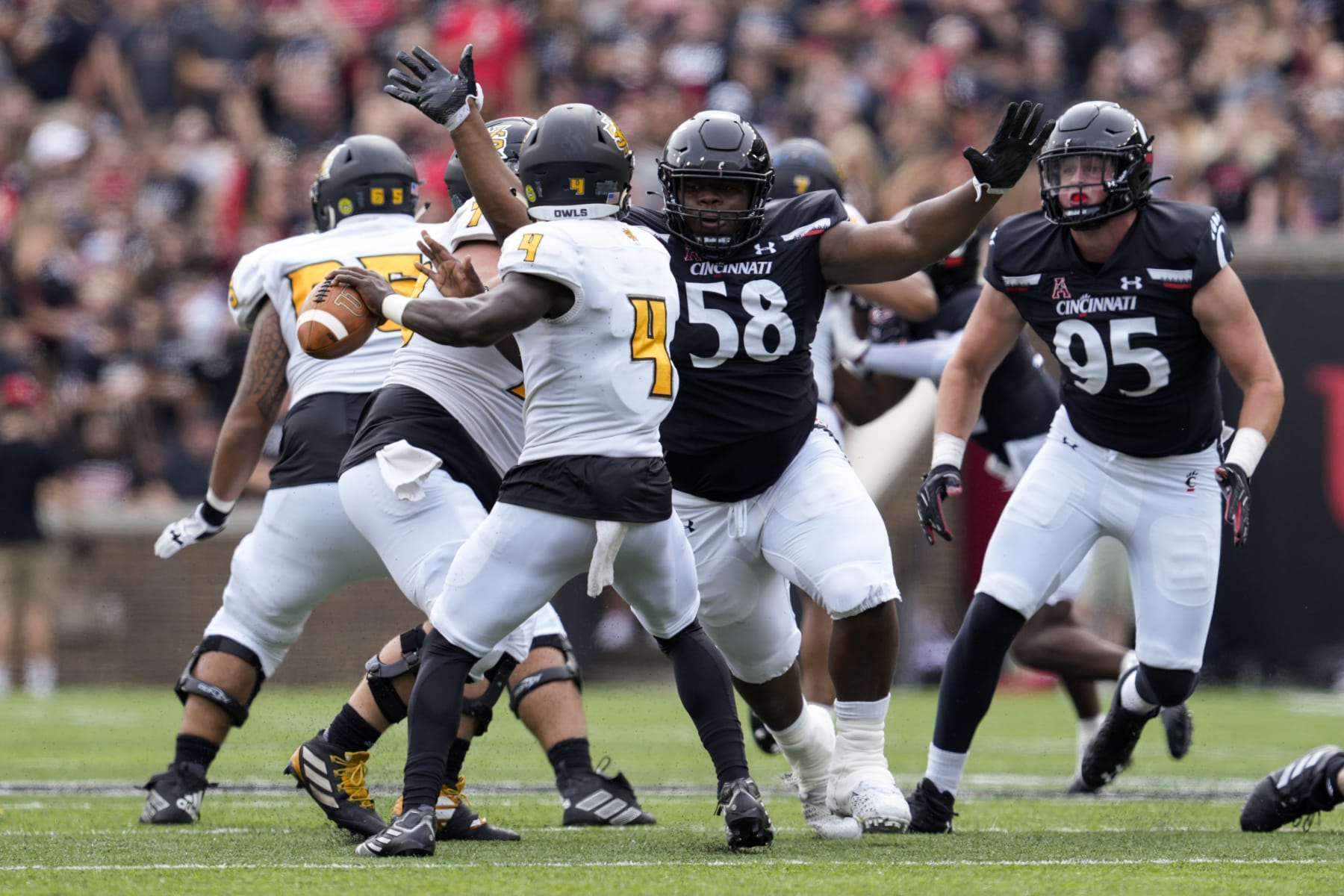 Cincinnati defensive lineman Dontay Corleone (58) completes a sack of Kennesaw State quarterback Jonathan Murphy (4) during the first half of an NCAA college football game Saturday, Sept. 10, 2022, in Cincinnati. (AP Photo/Jeff Dean)