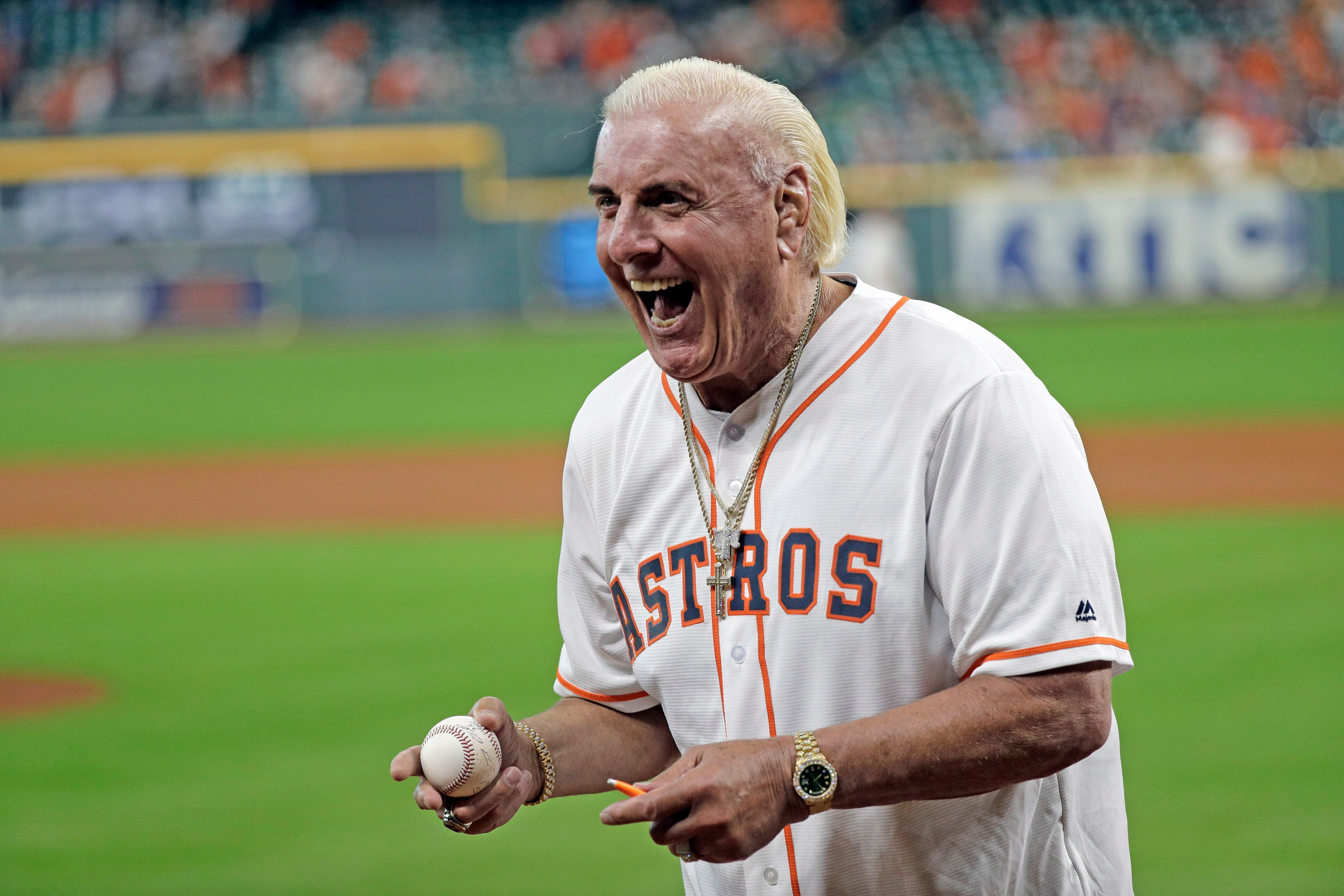 Former professional wrestler Ric Flair reacts after throwing out the ceremonial first pitch before a baseball game between the Detroit Tigers and Houston Astros Wednesday, Aug. 21, 2019, in Houston. (AP Photo/David J. Phillip)
