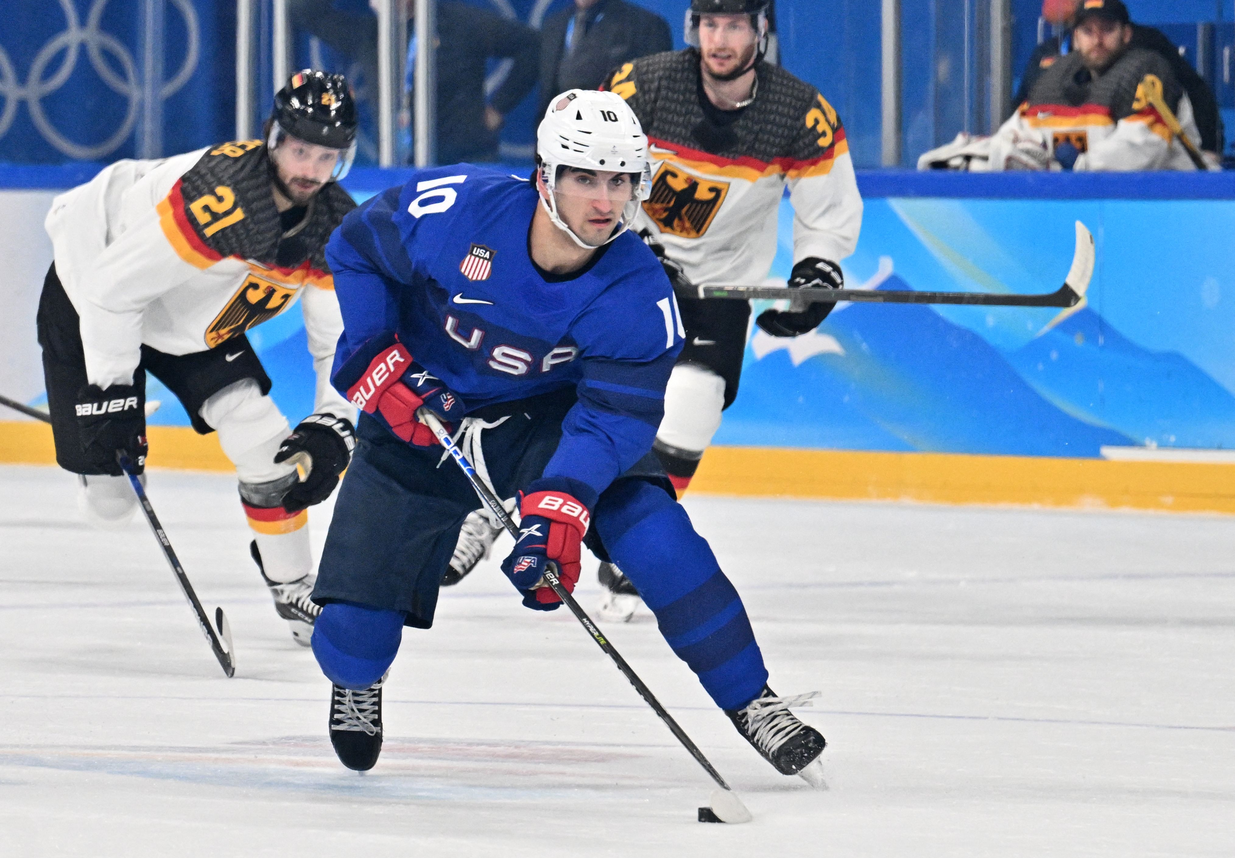 USA's Matty Beniers carries the puck during the men's preliminary round group A match of the Beijing 2022 Winter Olympic Games ice hockey competition between USA and Germany, at the Wukesong Sports Centre in Beijing on February 13, 2022. (Photo by ANTHONY WALLACE / AFP) (Photo by ANTHONY WALLACE/AFP via Getty Images)
