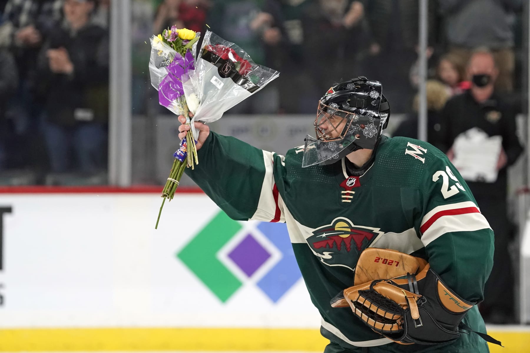 ST. PAUL, MN - MARCH 29: Minnesota Wild Goalie Marc-Andre Fleury (29) acknowledges the crowd after picking up several bouquets of flowers that were thrown onto the ice by fans after a game between the Minnesota Wild and Philadelphia Flyers on March 29, 2022, at Xcel Energy Center in St. Paul, MN.(Photo by Nick Wosika/Icon Sportswire via Getty Images)