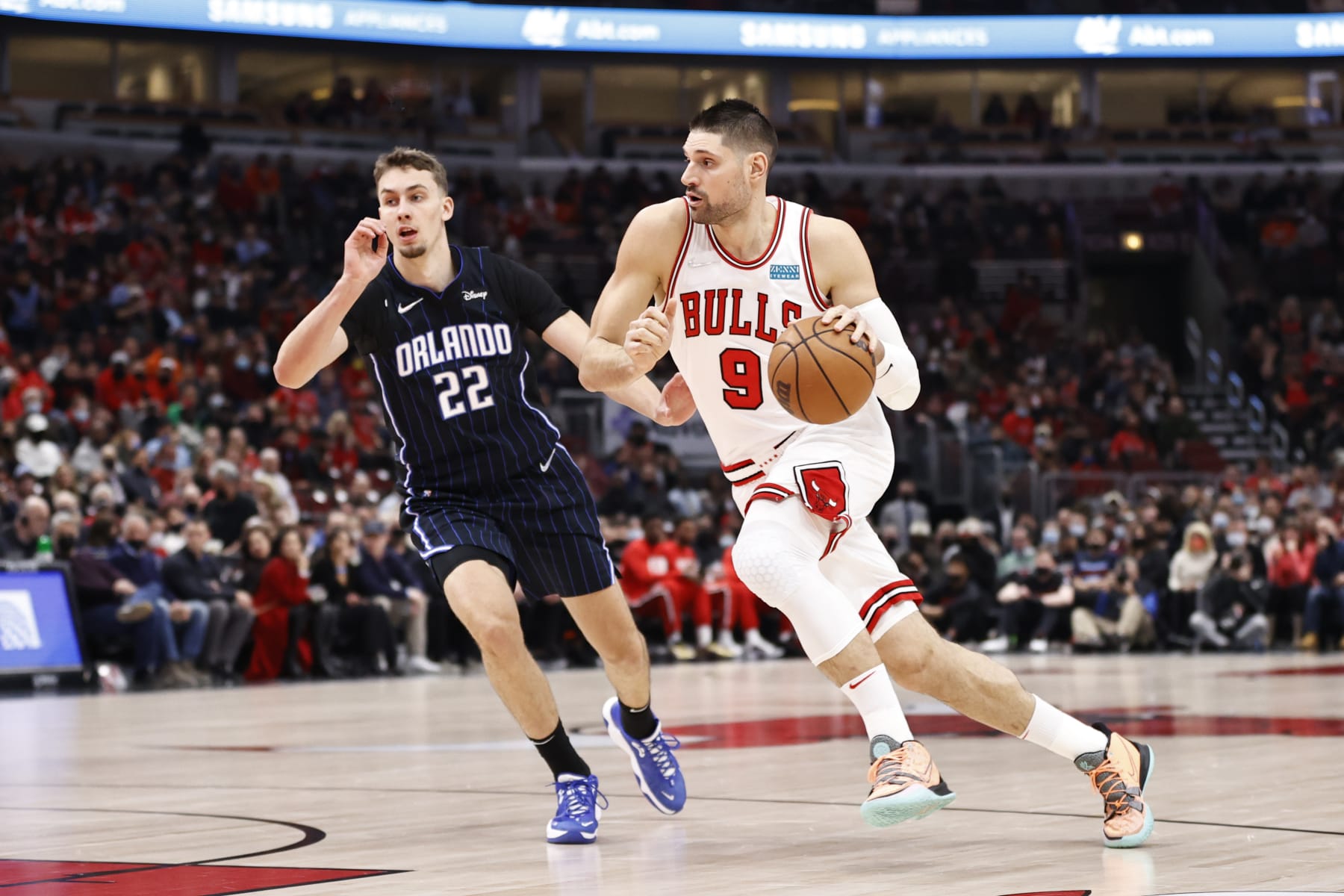 Chicago Bulls center Nikola Vucevic, right, drives to the basket against Orlando Magic forward Franz Wagner, left, during the first half of an NBA basketball game, Tuesday, Feb. 1, 2022, in Chicago. (AP Photo/Kamil Krzaczynski)