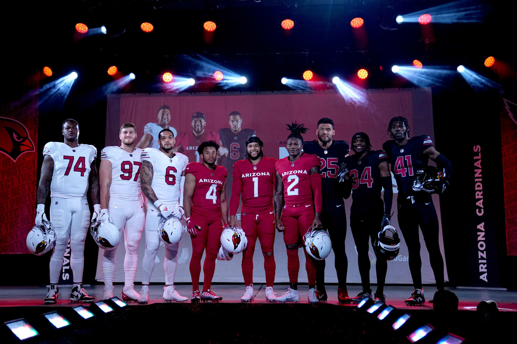 Arizona Cardinals quarterback Kyler Murray (1), flanked by teammates, showcase the NFL football teams' new uniforms for the 2023 season, Thursday, April 20, 2023, in Phoenix. (AP Photo/Matt York)
