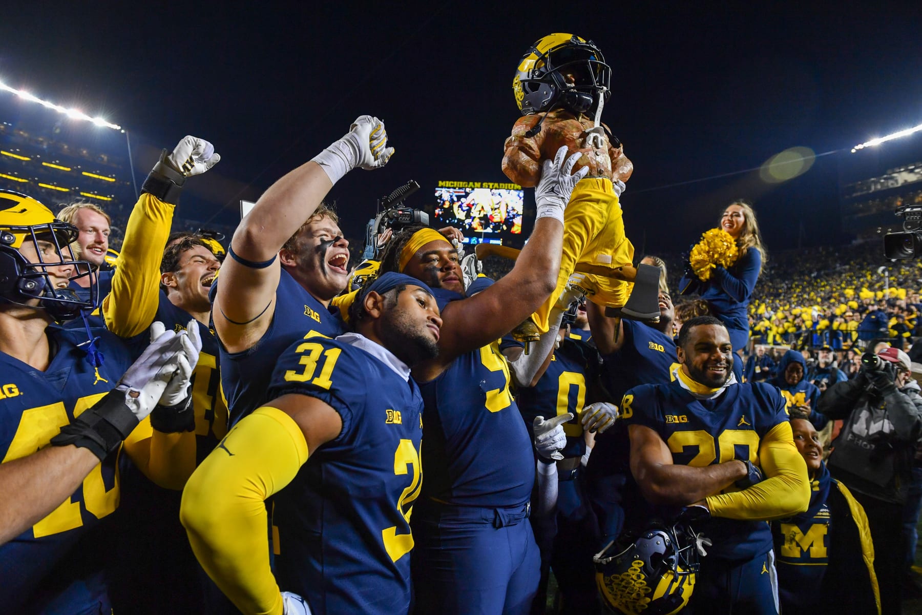 ANN ARBOR, MICHIGAN - OCTOBER 29: Mike Morris #90 and other players of the Michigan Wolverines celebrate with the Paul Bunyan trophy after winning a college football game against the Michigan State Spartans at Michigan Stadium on October 29, 2022 in Ann Arbor, Michigan. The Michigan Wolverines won the game 29-7 over the Michigan State Spartans. (Photo by Aaron J. Thornton/Getty Images)