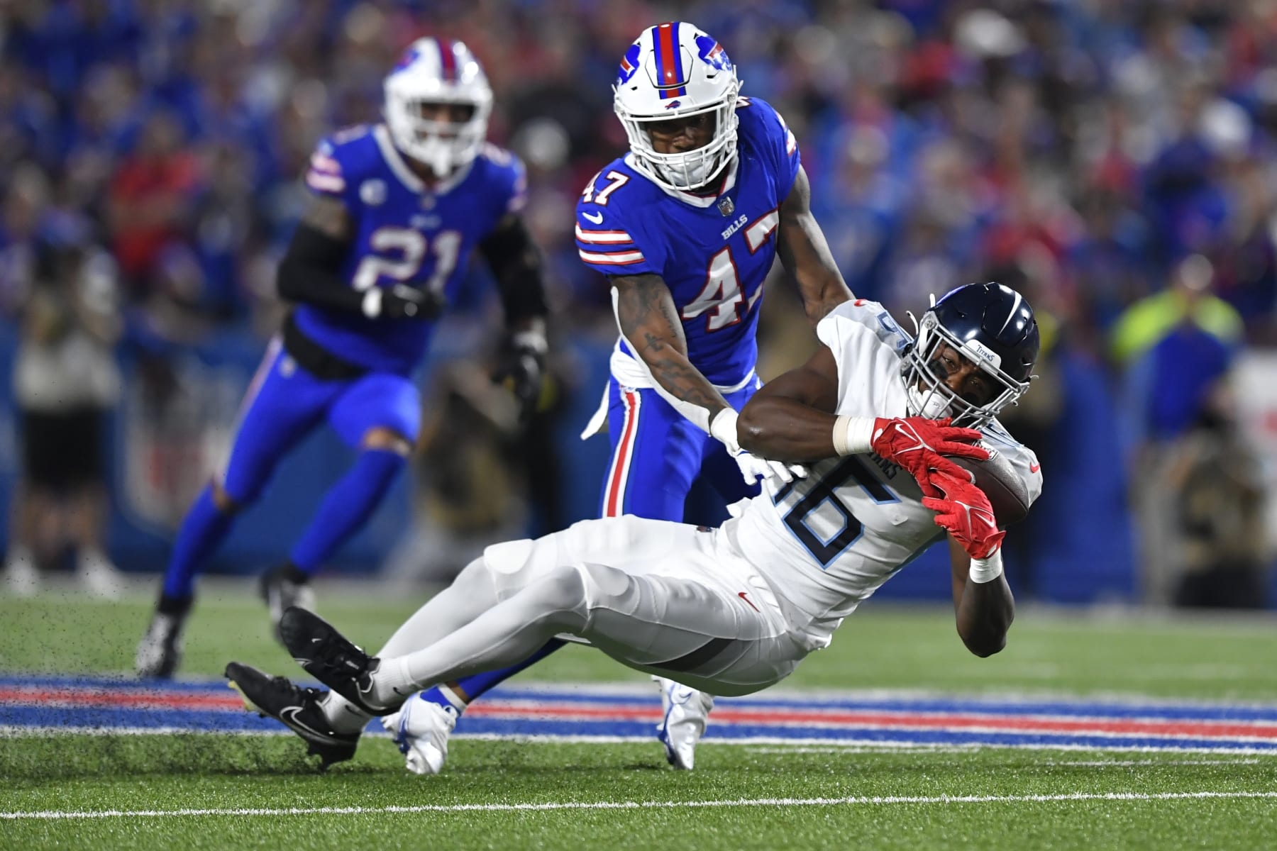 Tennessee Titans' Treylon Burks (16) catches a pass in front of Buffalo Bills' Christian Benford (47) during the first half of an NFL football game Monday, Sept. 19, 2022, in Orchard Park, N.Y. (AP Photo/Adrian Kraus)