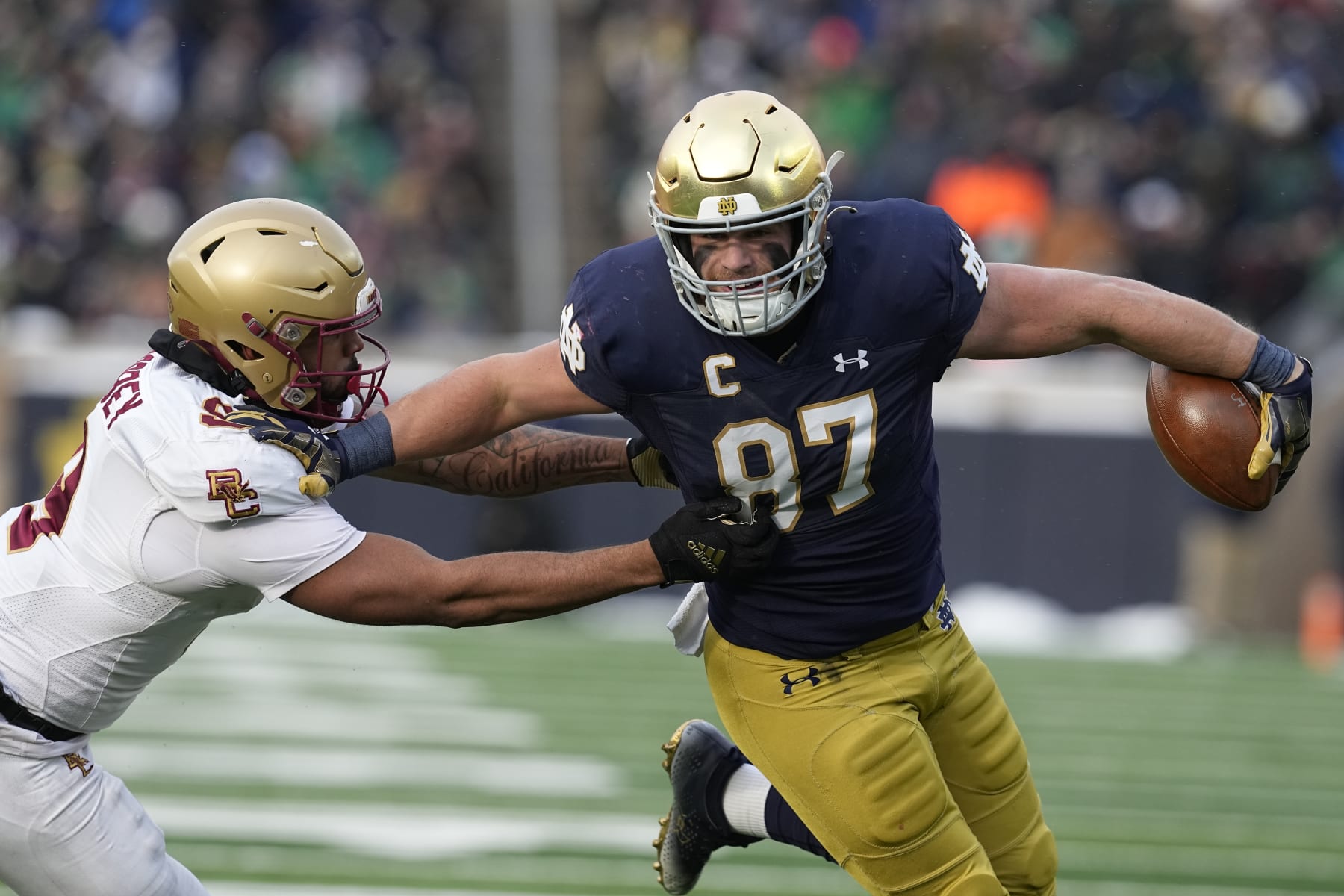 Notre Dame tight end Michael Mayer (87) runs past Boston College defensive back Jaiden Woodbey (9) during the first half of an NCAA college football game, Saturday, Nov. 19, 2022, in South Bend, Ind. (AP Photo/Darron Cummings)