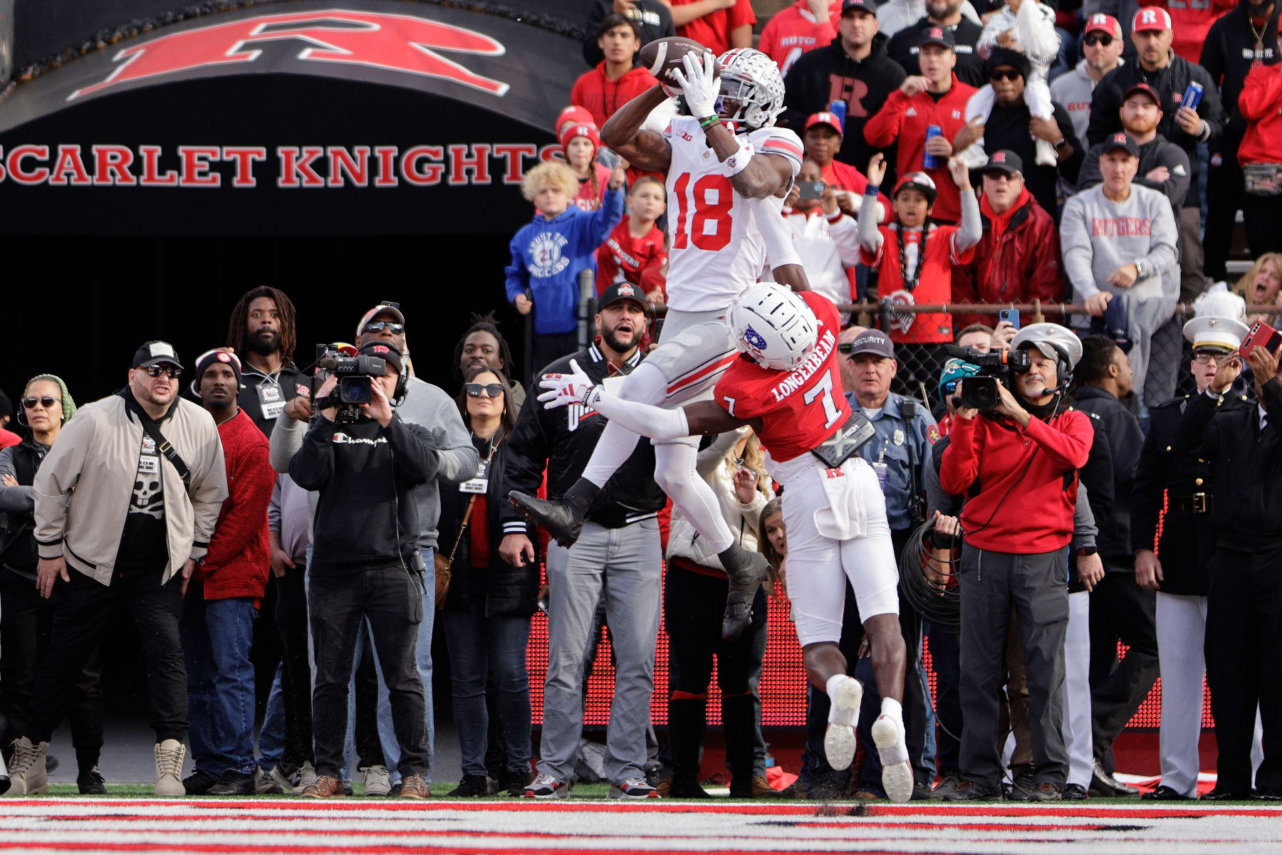 PISCATAWAY, NEW JERSEY - NOVEMBER 4: Wide receiver Marvin Harrison Jr. #18 of the Ohio State Buckeyes jumps over defensive back Robert Longerbeam #7 of the Rutgers Scarlet Knights to make a touchdown catch during the fourth quarter of a college football game at SHI Stadium on November 4, 2023 in Piscataway, New Jersey. Ohio State defeated Rutgers 35-16. (Photo by Rich Schultz/Getty Images)