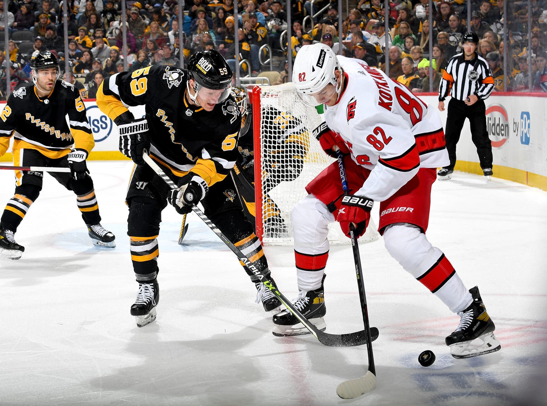 PITTSBURGH, PA - MARCH 13:  Jesperi Kotkaniemi #82 of the Carolina Hurricanes handles the puck against Jake Guentzel #59 of the Pittsburgh Penguins at PPG PAINTS Arena on March 13, 2022 in Pittsburgh, Pennsylvania. (Photo by Joe Sargent/NHLI via Getty Images)