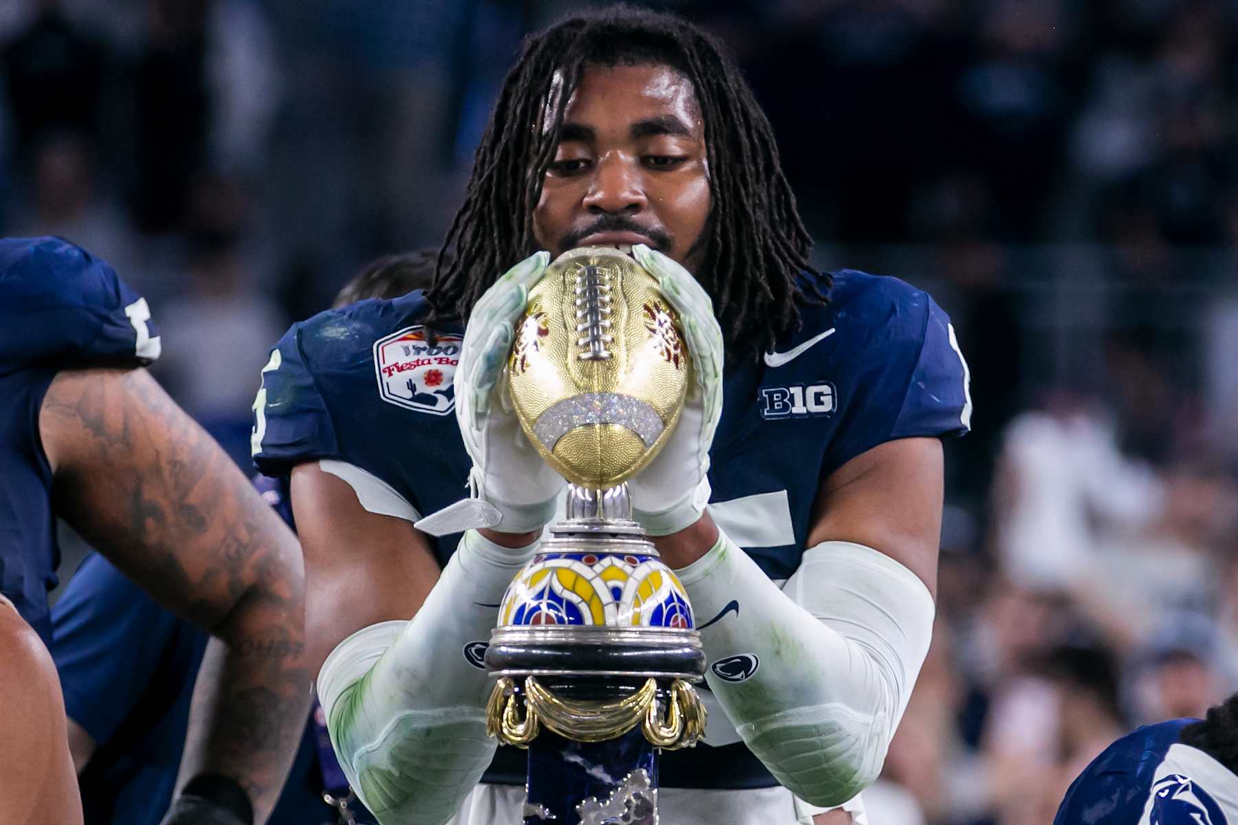 Penn State defensive end Amin Vanover (15) grasps the Bowl championship trophy after his teams victory during the Vrbo Fiesta Bowl