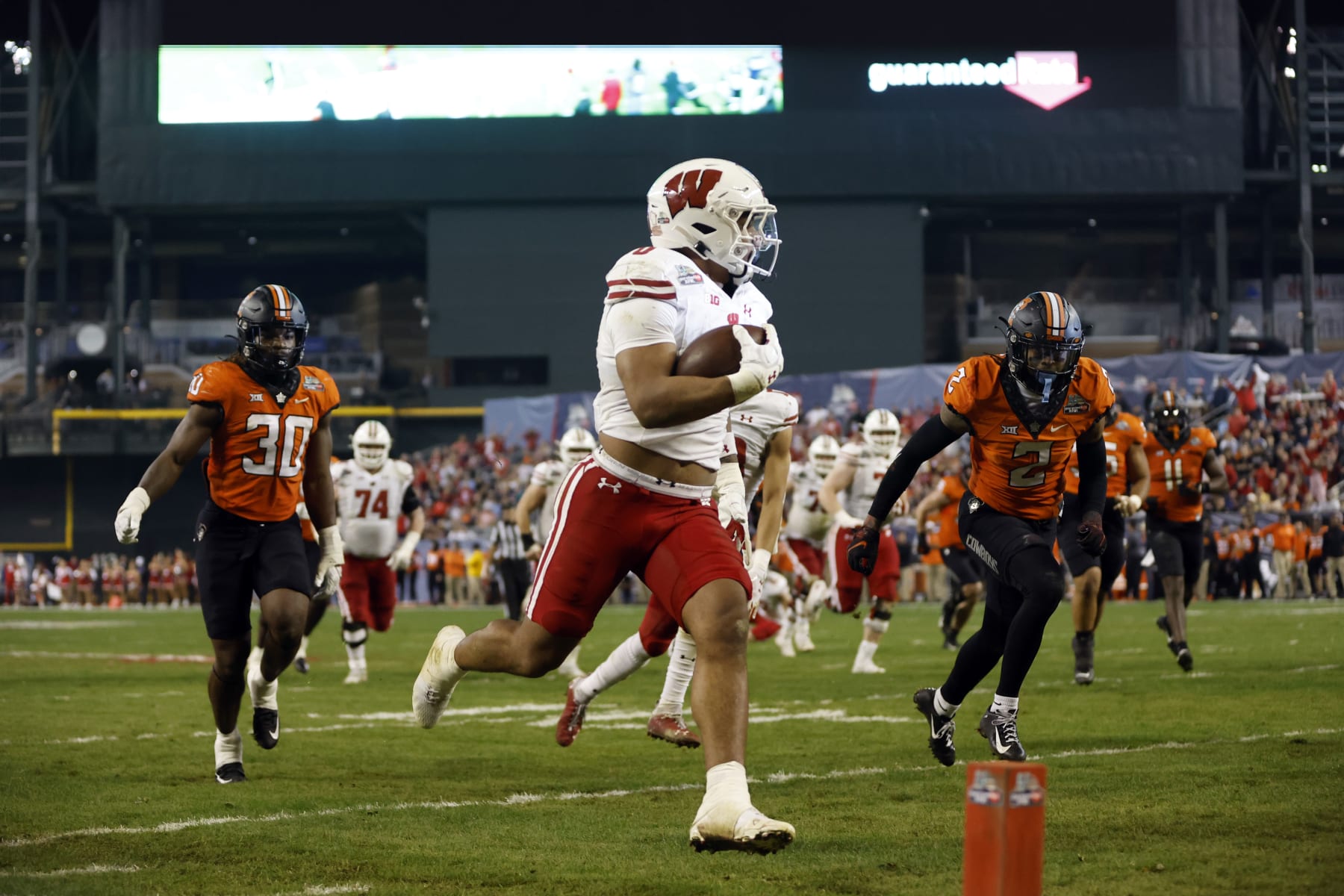 PHOENIX, ARIZONA - DECEMBER 27: Running back Braelon Allen #0 of the Wisconsin Badgers scores a touchdown during the second half of the Guaranteed Rate Bowl against the Oklahoma State Cowboys at Chase Field on December 27, 2022 in Phoenix, Arizona. The Badgers beat the Cowboys 24-17. (Photo by Chris Coduto/Getty Images)