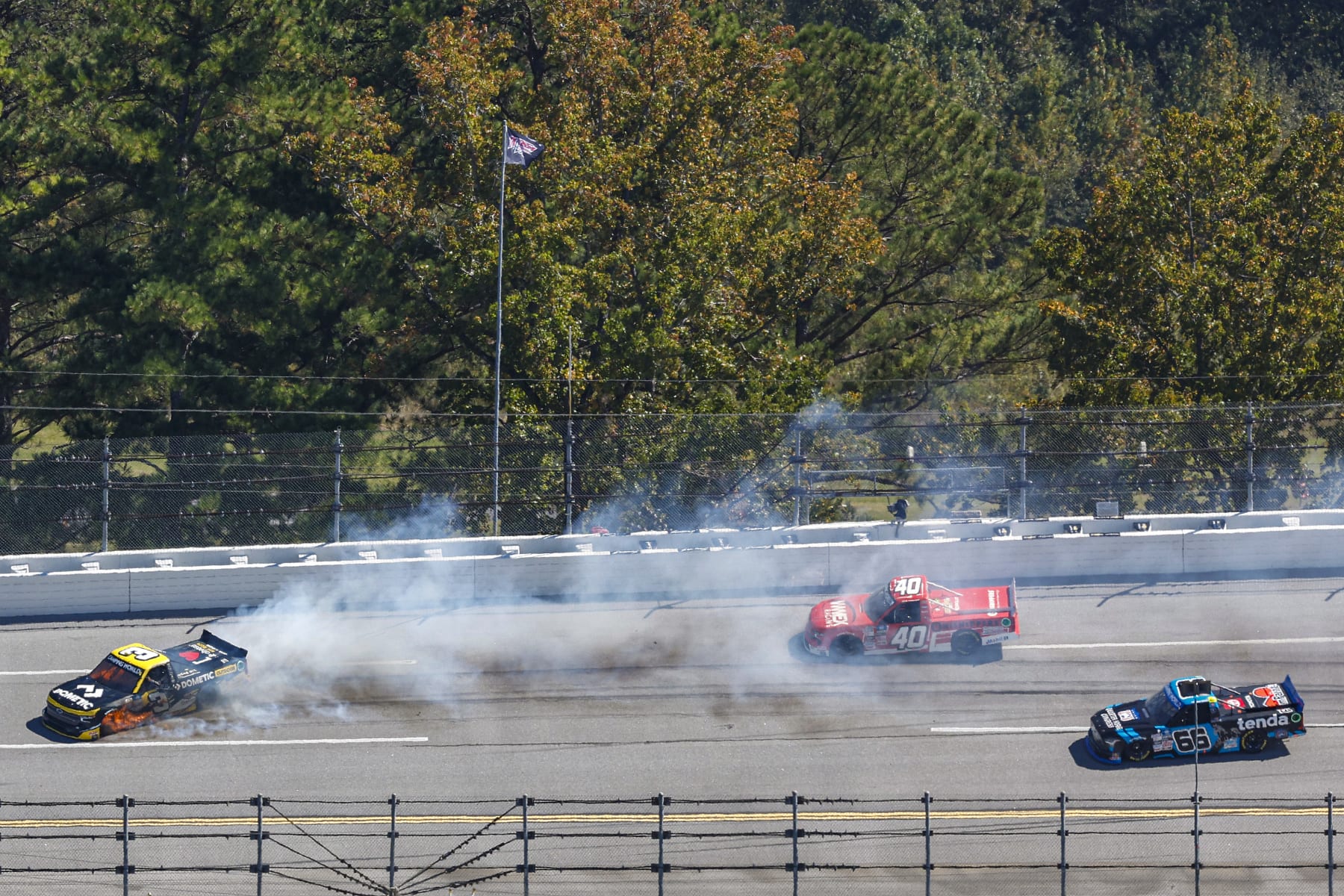 TALLADEGA, ALABAMA - OCTOBER 01: Jordan Anderson, driver of the #3 Dometic Outdoor Chevrolet, spins after an on-track incident in front of Dean Thompson, driver of the #40 WWEX Racing Chevrolet, and Ty Majeski, driver of the #66 Tenda/Quarter Horse Congress Toyota, during the NASCAR Camping World Truck Series Chevy Silverado 250 at Talladega Superspeedway on October 01, 2022 in Talladega, Alabama. (Photo by Chris Graythen/Getty Images)